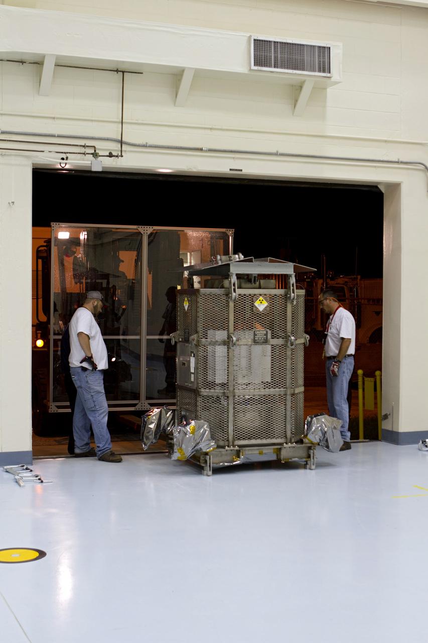 CAPE CANAVERAL, Fla. -- Department of Energy contractor employees roll the multi-mission radioisotope thermoelectric generator (MMRTG) for NASA's Mars Science Laboratory (MSL) mission, enclosed in a protective mesh container known as the "gorilla cage," toward a forklift outside the high bay of the RTG storage facility at NASA's Kennedy Space Center in Florida for its move to the Payload Hazardous Servicing Facility (PHSF).  The cage protects the MMRTG and allows any excess heat generated to dissipate into the air.  In the PHSF, the MMRTG temporarily will be installed on the MSL rover, Curiosity, for a fit check but will be installed on the rover for launch at the pad.    The MMRTG will generate the power needed for the mission from the natural decay of plutonium-238, a non-weapons-grade form of the radioisotope. Heat given off by this natural decay will provide constant power through the day and night during all seasons. Curiosity, MSL's car-sized rover, has 10 science instruments designed to search for signs of life, including methane, and help determine if the gas is from a biological or geological source. Waste heat from the MMRTG will be circulated throughout the rover system to keep instruments, computers, mechanical devices and communications systems within their operating temperature ranges. Launch of MSL aboard a United Launch Alliance Atlas V rocket is planned for Nov. 25 from Space Launch Complex 41 on Cape Canaveral Air Force Station. For more information, visit http://www.nasa.gov/msl. Photo credit: NASA/Cory Huston