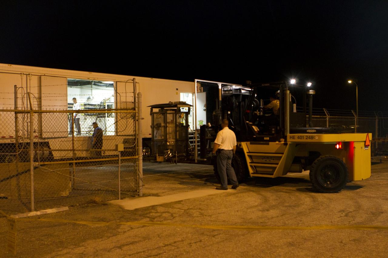 CAPE CANAVERAL, Fla. -- Outside the RTG storage facility at NASA's Kennedy Space Center in Florida, a forklift carries the protective mesh container, known as the "gorilla cage," enclosing the multi-mission radioisotope thermoelectric generator (MMRTG) for NASA's Mars Science Laboratory (MSL) mission toward the MMRTG trailer that will transport it to the Payload Hazardous Servicing Facility (PHSF).  The cage protects the MMRTG and allows any excess heat generated to dissipate into the air.  In the PHSF, the MMRTG temporarily will be installed on the MSL rover, Curiosity, for a fit check but will be installed on the rover for launch at the pad.    The MMRTG will generate the power needed for the mission from the natural decay of plutonium-238, a non-weapons-grade form of the radioisotope. Heat given off by this natural decay will provide constant power through the day and night during all seasons. Curiosity, MSL's car-sized rover, has 10 science instruments designed to search for signs of life, including methane, and help determine if the gas is from a biological or geological source. Waste heat from the MMRTG will be circulated throughout the rover system to keep instruments, computers, mechanical devices and communications systems within their operating temperature ranges. Launch of MSL aboard a United Launch Alliance Atlas V rocket is planned for Nov. 25 from Space Launch Complex 41 on Cape Canaveral Air Force Station. For more information, visit http://www.nasa.gov/msl. Photo credit: NASA/Cory Huston