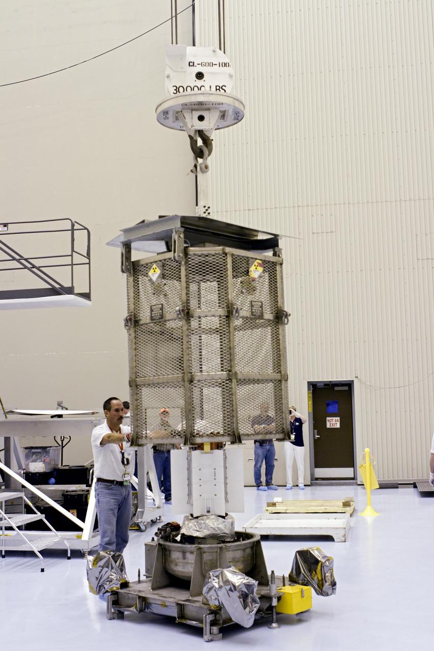 CAPE CANAVERAL, Fla. -- In the airlock of the Payload Hazardous Servicing Facility (PHSF) at NASA's Kennedy Space Center in Florida, the protective mesh container enclosing the multi-mission radioisotope thermoelectric generator (MMRTG) for NASA's Mars Science Laboratory (MSL) mission is lifted from around the MMRTG. The container, known as the "gorilla cage," protects the MMRTG during transport and allows any excess heat generated to dissipate into the air. In the PHSF, the MMRTG temporarily will be installed on the MSL rover, Curiosity, for a fit check but will be installed on the rover for launch at the pad. The MMRTG will generate the power needed for the mission from the natural decay of plutonium-238, a non-weapons-grade form of the radioisotope. Heat given off by this natural decay will provide constant power through the day and night during all seasons. Curiosity, MSL's car-sized rover, has 10 science instruments designed to search for signs of life, including methane, and help determine if the gas is from a biological or geological source. Waste heat from the MMRTG will be circulated throughout the rover system to keep instruments, computers, mechanical devices and communications systems within their operating temperature ranges. Launch of MSL aboard a United Launch Alliance Atlas V rocket is planned for Nov. 25 from Space Launch Complex 41 on Cape Canaveral Air Force Station. For more information, visit http://www.nasa.gov/msl. Photo credit: NASA/Cory Huston