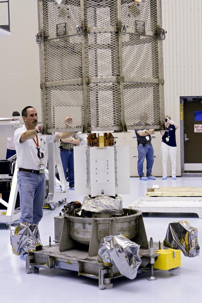 CAPE CANAVERAL, Fla. -- In the airlock of the Payload Hazardous Servicing Facility (PHSF) at NASA's Kennedy Space Center in Florida, the protective mesh container enclosing the multi-mission radioisotope thermoelectric generator (MMRTG) for NASA's Mars Science Laboratory (MSL) mission is lifted from around the MMRTG. The container, known as the "gorilla cage," protects the MMRTG during transport and allows any excess heat generated to dissipate into the air.  In the PHSF, the MMRTG temporarily will be installed on the MSL rover, Curiosity, for a fit check but will be installed on the rover for launch at the pad.    The MMRTG will generate the power needed for the mission from the natural decay of plutonium-238, a non-weapons-grade form of the radioisotope. Heat given off by this natural decay will provide constant power through the day and night during all seasons. Curiosity, MSL's car-sized rover, has 10 science instruments designed to search for signs of life, including methane, and help determine if the gas is from a biological or geological source. Waste heat from the MMRTG will be circulated throughout the rover system to keep instruments, computers, mechanical devices and communications systems within their operating temperature ranges. Launch of MSL aboard a United Launch Alliance Atlas V rocket is planned for Nov. 25 from Space Launch Complex 41 on Cape Canaveral Air Force Station. For more information, visit http://www.nasa.gov/msl. Photo credit: NASA/Cory Huston