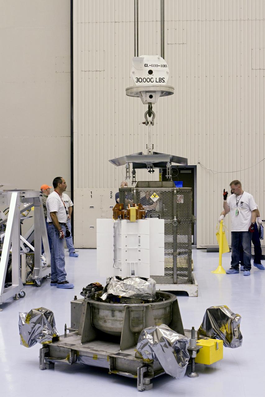 CAPE CANAVERAL, Fla. -- In the airlock of the Payload Hazardous Servicing Facility (PHSF) at NASA's Kennedy Space Center in Florida, the protective mesh container enclosing the multi-mission radioisotope thermoelectric generator (MMRTG) for NASA's Mars Science Laboratory (MSL) mission is lowered to the floor of the airlock beside the MMRTG. The container, known as the "gorilla cage," protects the MMRTG during transport and allows any excess heat generated to dissipate into the air.  Next, the airlock will be transitioned into a clean room by purging the air of any particles. In the PHSF, the MMRTG temporarily will be installed on the MSL rover, Curiosity, for a fit check but will be installed on the rover for launch at the pad.    The MMRTG will generate the power needed for the mission from the natural decay of plutonium-238, a non-weapons-grade form of the radioisotope. Heat given off by this natural decay will provide constant power through the day and night during all seasons. Curiosity, MSL's car-sized rover, has 10 science instruments designed to search for signs of life, including methane, and help determine if the gas is from a biological or geological source. Waste heat from the MMRTG will be circulated throughout the rover system to keep instruments, computers, mechanical devices and communications systems within their operating temperature ranges. Launch of MSL aboard a United Launch Alliance Atlas V rocket is planned for Nov. 25 from Space Launch Complex 41 on Cape Canaveral Air Force Station. For more information, visit http://www.nasa.gov/msl. Photo credit: NASA/Cory Huston
