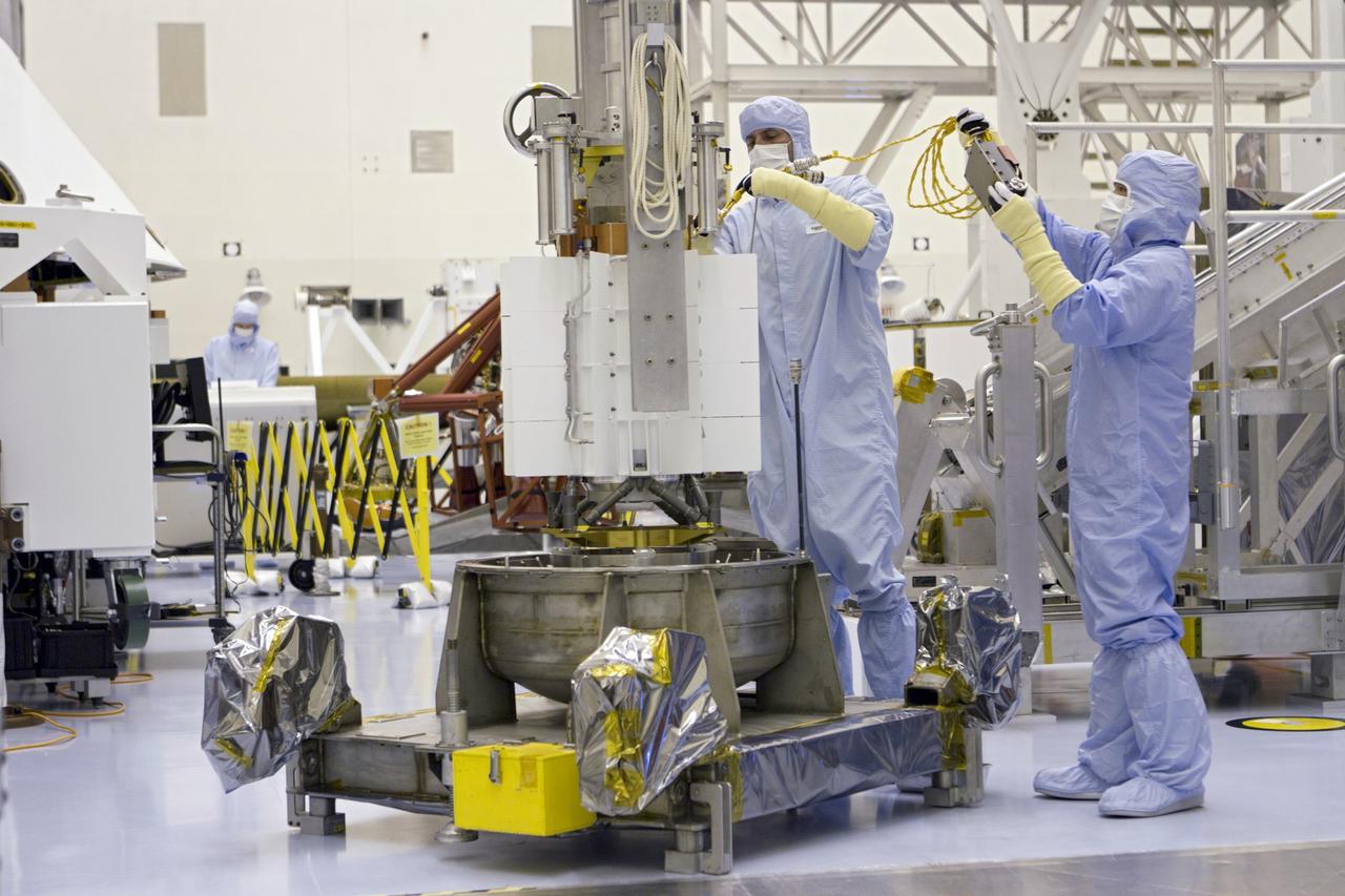 CAPE CANAVERAL, Fla. -- In the high bay of the Payload Hazardous Servicing Facility (PHSF) at NASA's Kennedy Space Center in Florida, spacecraft technicians from NASA's Jet Propulsion Laboratory attach guide ropes to the turning fixture connected to the multi-mission radioisotope thermoelectric generator (MMRTG) for NASA's Mars Science Laboratory (MSL) mission during preparations to lift it from its support base. The turning fixture will lift and lower the MMRTG onto the MMRTG integration cart. The cart will be used to install the MMRTG on Curiosity for a fit check. The MMRTG will be installed on the rover for launch at the pad.    The MMRTG will generate the power needed for the mission from the natural decay of plutonium-238, a non-weapons-grade form of the radioisotope. Heat given off by this natural decay will provide constant power through the day and night during all seasons. Curiosity, MSL's car-sized rover, has 10 science instruments designed to search for signs of life, including methane, and help determine if the gas is from a biological or geological source. Waste heat from the MMRTG will be circulated throughout the rover system to keep instruments, computers, mechanical devices and communications systems within their operating temperature ranges. Launch of MSL aboard a United Launch Alliance Atlas V rocket is planned for Nov. 25 from Space Launch Complex 41 on Cape Canaveral Air Force Station. For more information, visit http://www.nasa.gov/msl. Photo credit: NASA/Cory Huston