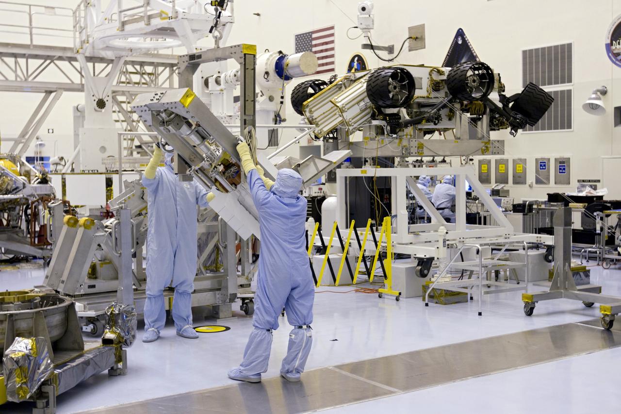 CAPE CANAVERAL, Fla. -- In the high bay of the Payload Hazardous Servicing Facility (PHSF) at NASA's Kennedy Space Center in Florida, spacecraft technicians from NASA's Jet Propulsion Laboratory rotate the multi-mission radioisotope thermoelectric generator (MMRTG) for NASA's Mars Science Laboratory (MSL) mission, using the turning fixture to align the MMRTG with the angle of the MMRTG integration cart behind it. The cart will be used to install the MMRTG on the Curiosity rover for a fit check. The rover is on an elevated work stand, at right. The MMRTG will be installed on the rover for launch at the pad. The MMRTG will generate the power needed for the mission from the natural decay of plutonium-238, a non-weapons-grade form of the radioisotope. Heat given off by this natural decay will provide constant power through the day and night during all seasons. Curiosity, MSL's car-sized rover, has 10 science instruments designed to search for signs of life, including methane, and help determine if the gas is from a biological or geological source. Waste heat from the MMRTG will be circulated throughout the rover system to keep instruments, computers, mechanical devices and communications systems within their operating temperature ranges. Launch of MSL aboard a United Launch Alliance Atlas V rocket is planned for Nov. 25 from Space Launch Complex 41 on Cape Canaveral Air Force Station. For more information, visit http://www.nasa.gov/msl. Photo credit: NASA/Cory Huston
