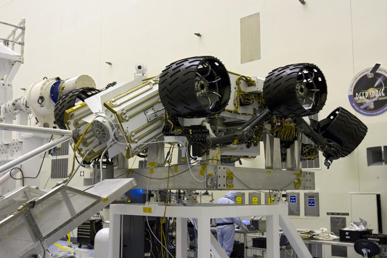 CAPE CANAVERAL, Fla. -- In the high bay of the Payload Hazardous Servicing Facility (PHSF) at NASA's Kennedy Space Center in Florida, the multi-mission radioisotope thermoelectric generator (MMRTG) for NASA's Mars Science Laboratory (MSL) mission is installed onto the aft of the Curiosity rover for a fit check. In view are the MMRTG's cooling fins which function like the radiator on a car and will reflect any excess heat generated by the MMRTG to prevent interference with the rover's electronics. Next, the MMRTG will be removed and later installed on the rover for launch at the pad.    The MMRTG will generate the power needed for the mission from the natural decay of plutonium-238, a non-weapons-grade form of the radioisotope. Heat given off by this natural decay will provide constant power through the day and night during all seasons. Curiosity, MSL's car-sized rover, has 10 science instruments designed to search for signs of life, including methane, and help determine if the gas is from a biological or geological source. Waste heat from the MMRTG will be circulated throughout the rover system to keep instruments, computers, mechanical devices and communications systems within their operating temperature ranges. Launch of MSL aboard a United Launch Alliance Atlas V rocket is planned for Nov. 25 from Space Launch Complex 41 on Cape Canaveral Air Force Station. For more information, visit http://www.nasa.gov/msl. Photo credit: NASA/Cory Huston