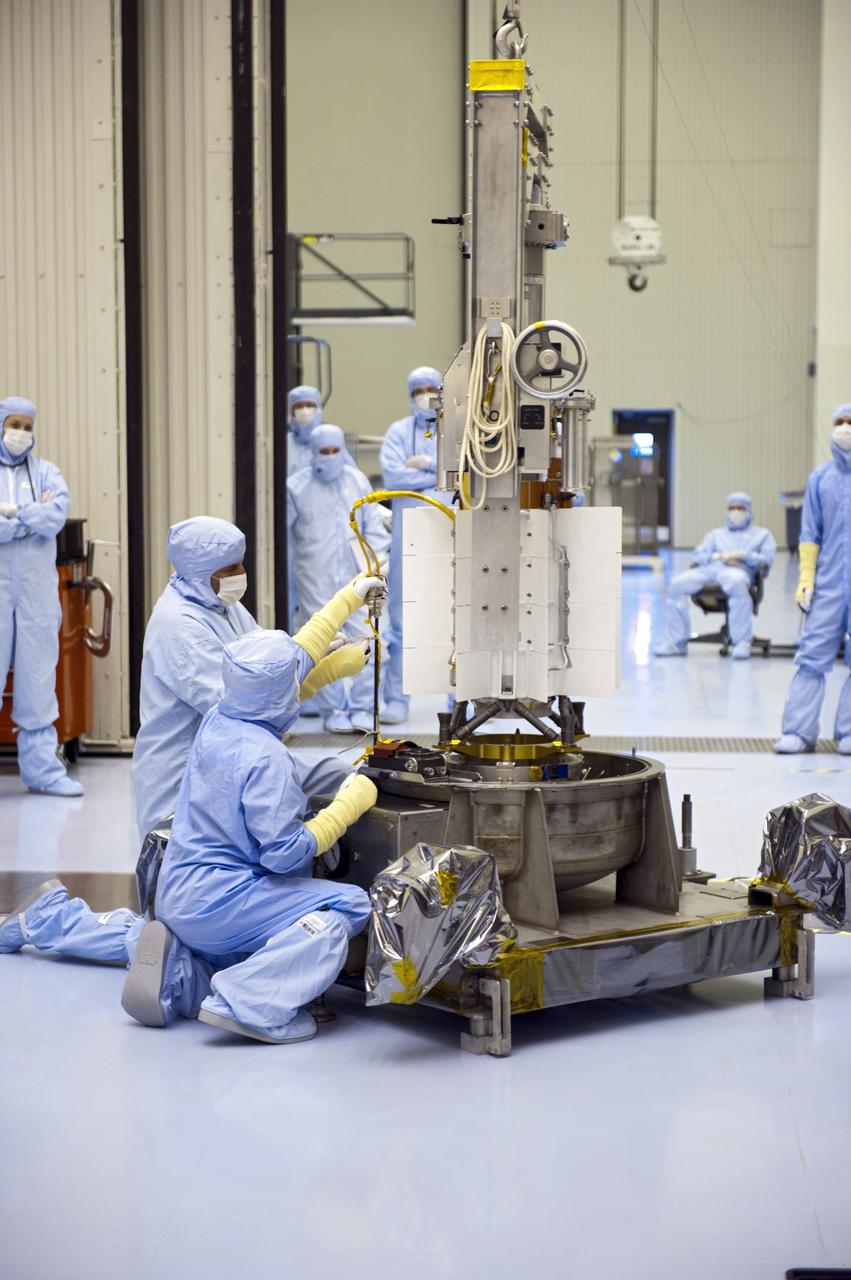 CAPE CANAVERAL, Fla. -- In the high bay of the Payload Hazardous Servicing Facility at NASA's Kennedy Space Center in Florida, the multi-mission radioisotope thermoelectric generator (MMRTG) for NASA's Mars Science Laboratory (MSL) mission is lowered onto a support base with the aid of a turning fixture following the MMRTG fit check on the Curiosity rover.    The MMRTG will generate the power needed for the mission from the natural decay of plutonium-238, a non-weapons-grade form of the radioisotope. Heat given off by this natural decay will provide constant power through the day and night during all seasons. MSL's components include a car-sized rover, Curiosity, which has 10 science instruments designed to search for signs of life, including methane, and help determine if the gas is from a biological or geological source. Waste heat from the MMRTG will be circulated throughout the rover system to keep instruments, computers, mechanical devices and communications systems within their operating temperature ranges. Launch of MSL aboard a United Launch Alliance Atlas V rocket is targeted for Nov. 25 from Space Launch Complex 41 on Cape Canaveral Air Force Station. For more information, visit http://www.nasa.gov/msl. Photo credit: NASA/Kim Shiflett