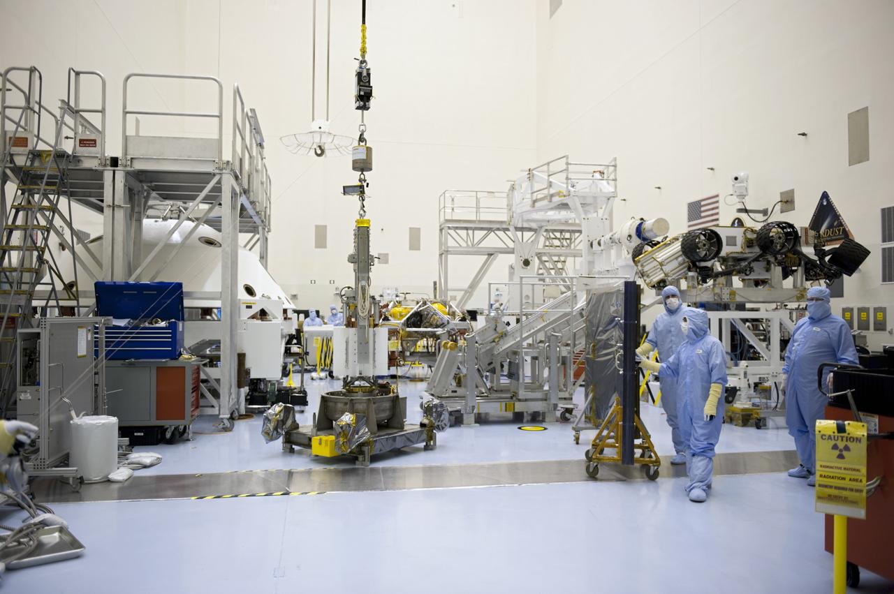 CAPE CANAVERAL, Fla. -- In the high bay of the Payload Hazardous Servicing Facility at NASA's Kennedy Space Center in Florida, the multi-mission radioisotope thermoelectric generator (MMRTG) for NASA's Mars Science Laboratory (MSL) mission, still connected to the turning fixture, rests on a support base following the MMRTG fit check on the Curiosity rover. A mobile plexiglass radiation shield is in place between the MMRTG and the spacecraft technicians, at right, to help minimize the employees' radiation exposure.    The MMRTG will generate the power needed for the mission from the natural decay of plutonium-238, a non-weapons-grade form of the radioisotope. Heat given off by this natural decay will provide constant power through the day and night during all seasons. MSL's components include a car-sized rover, Curiosity, which has 10 science instruments designed to search for signs of life, including methane, and help determine if the gas is from a biological or geological source. Waste heat from the MMRTG will be circulated throughout the rover system to keep instruments, computers, mechanical devices and communications systems within their operating temperature ranges. Launch of MSL aboard a United Launch Alliance Atlas V rocket is targeted for Nov. 25 from Space Launch Complex 41 on Cape Canaveral Air Force Station. For more information, visit http://www.nasa.gov/msl. Photo credit: NASA/Kim Shiflett