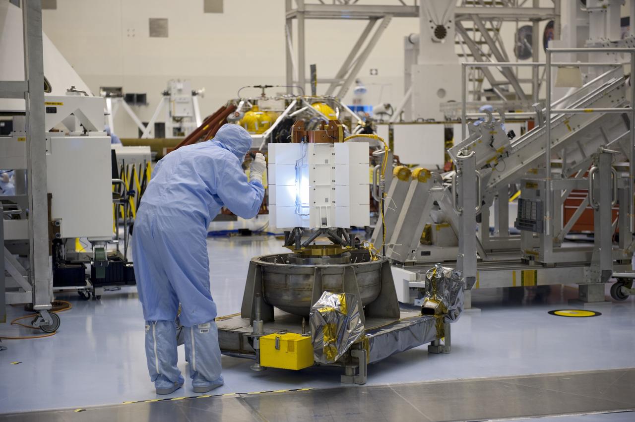 CAPE CANAVERAL, Fla. -- In the high bay of the Payload Hazardous Servicing Facility at NASA's Kennedy Space Center in Florida, a spacecraft technician from NASA's Jet Propulsion Laboratory conducts a visual inspection of the cooling tubes on the exterior of the multi-mission radioisotope thermoelectric generator (MMRTG) for NASA's Mars Science Laboratory (MSL) mission following the MMRTG fit check on the Curiosity rover.    The MMRTG will generate the power needed for the mission from the natural decay of plutonium-238, a non-weapons-grade form of the radioisotope. Heat given off by this natural decay will provide constant power through the day and night during all seasons. MSL's components include a car-sized rover, Curiosity, which has 10 science instruments designed to search for signs of life, including methane, and help determine if the gas is from a biological or geological source. Waste heat from the MMRTG will be circulated throughout the rover system to keep instruments, computers, mechanical devices and communications systems within their operating temperature ranges. Launch of MSL aboard a United Launch Alliance Atlas V rocket is targeted for Nov. 25 from Space Launch Complex 41 on Cape Canaveral Air Force Station. For more information, visit http://www.nasa.gov/msl. Photo credit: NASA/Kim Shiflett