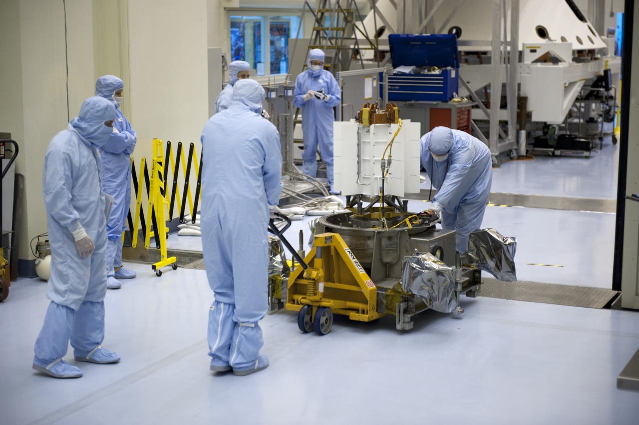 CAPE CANAVERAL, Fla. -- In the Payload Hazardous Servicing Facility at NASA's Kennedy Space Center in Florida, spacecraft technicians from NASA's Jet Propulsion Laboratory roll the multi-mission radioisotope thermoelectric generator (MMRTG) for NASA's Mars Science Laboratory (MSL) mission on its support base from the high bay into the airlock following the MMRTG fit check on the Curiosity rover.     The MMRTG will generate the power needed for the mission from the natural decay of plutonium-238, a non-weapons-grade form of the radioisotope. Heat given off by this natural decay will provide constant power through the day and night during all seasons. MSL's components include a car-sized rover, Curiosity, which has 10 science instruments designed to search for signs of life, including methane, and help determine if the gas is from a biological or geological source. Waste heat from the MMRTG will be circulated throughout the rover system to keep instruments, computers, mechanical devices and communications systems within their operating temperature ranges. Launch of MSL aboard a United Launch Alliance Atlas V rocket is targeted for Nov. 25 from Space Launch Complex 41 on Cape Canaveral Air Force Station. For more information, visit http://www.nasa.gov/msl. Photo credit: NASA/Kim Shiflett