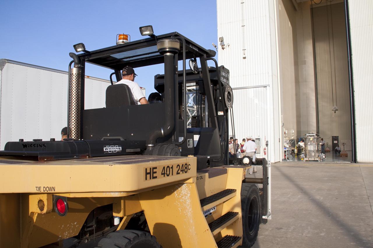 CAPE CANAVERAL, Fla. -- A forklift approaches the airlock of the Payload Hazardous Servicing Facility (PHSF) at NASA's Kennedy Space Center in Florida where the multi-mission radioisotope thermoelectric generator (MMRTG) for NASA's Mars Science Laboratory (MSL) mission awaits transport to the RTG storage facility. The MMRTG is enclosed in a mesh container, known as the "gorilla cage," which protects it during transport and allows any excess heat generated to dissipate into the air.  The MMRTG was in the PHSF for a fit check on MSL's Curiosity rover.    The MMRTG will generate the power needed for the mission from the natural decay of plutonium-238, a non-weapons-grade form of the radioisotope. Heat given off by this natural decay will provide constant power through the day and night during all seasons. MSL's components include a compact car-sized rover, Curiosity, which has 10 science instruments designed to search for signs of life, including methane, and help determine if the gas is from a biological or geological source. Waste heat from the MMRTG will be circulated throughout the rover system to keep instruments, computers, mechanical devices and communications systems within their operating temperature ranges. Launch of MSL aboard a United Launch Alliance Atlas V rocket is targeted for Nov. 25 from Space Launch Complex 41 on Cape Canaveral Air Force Station. For more information, visit http://www.nasa.gov/msl. Photo credit: NASA/Troy Cryder