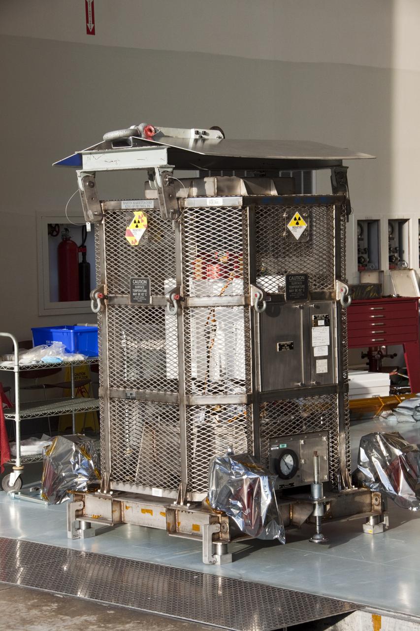 CAPE CANAVERAL, Fla. -- In the airlock of the Payload Hazardous Servicing Facility (PHSF) at NASA's Kennedy Space Center in Florida, t he multi-mission radioisotope thermoelectric generator (MMRTG) for NASA's Mars Science Laboratory (MSL) mission awaits transport to the RTG storage facility. The MMRTG is enclosed in a mesh container, known as the "gorilla cage," which protects it during transport and allows any excess heat generated to dissipate into the air.  The MMRTG was in the PHSF for a fit check on MSL's Curiosity rover.    The MMRTG will generate the power needed for the mission from the natural decay of plutonium-238, a non-weapons-grade form of the radioisotope. Heat given off by this natural decay will provide constant power through the day and night during all seasons. MSL's components include a compact car-sized rover, Curiosity, which has 10 science instruments designed to search for signs of life, including methane, and help determine if the gas is from a biological or geological source. Waste heat from the MMRTG will be circulated throughout the rover system to keep instruments, computers, mechanical devices and communications systems within their operating temperature ranges. Launch of MSL aboard a United Launch Alliance Atlas V rocket is targeted for Nov. 25 from Space Launch Complex 41 on Cape Canaveral Air Force Station. For more information, visit http://www.nasa.gov/msl. Photo credit: NASA/Troy Cryder