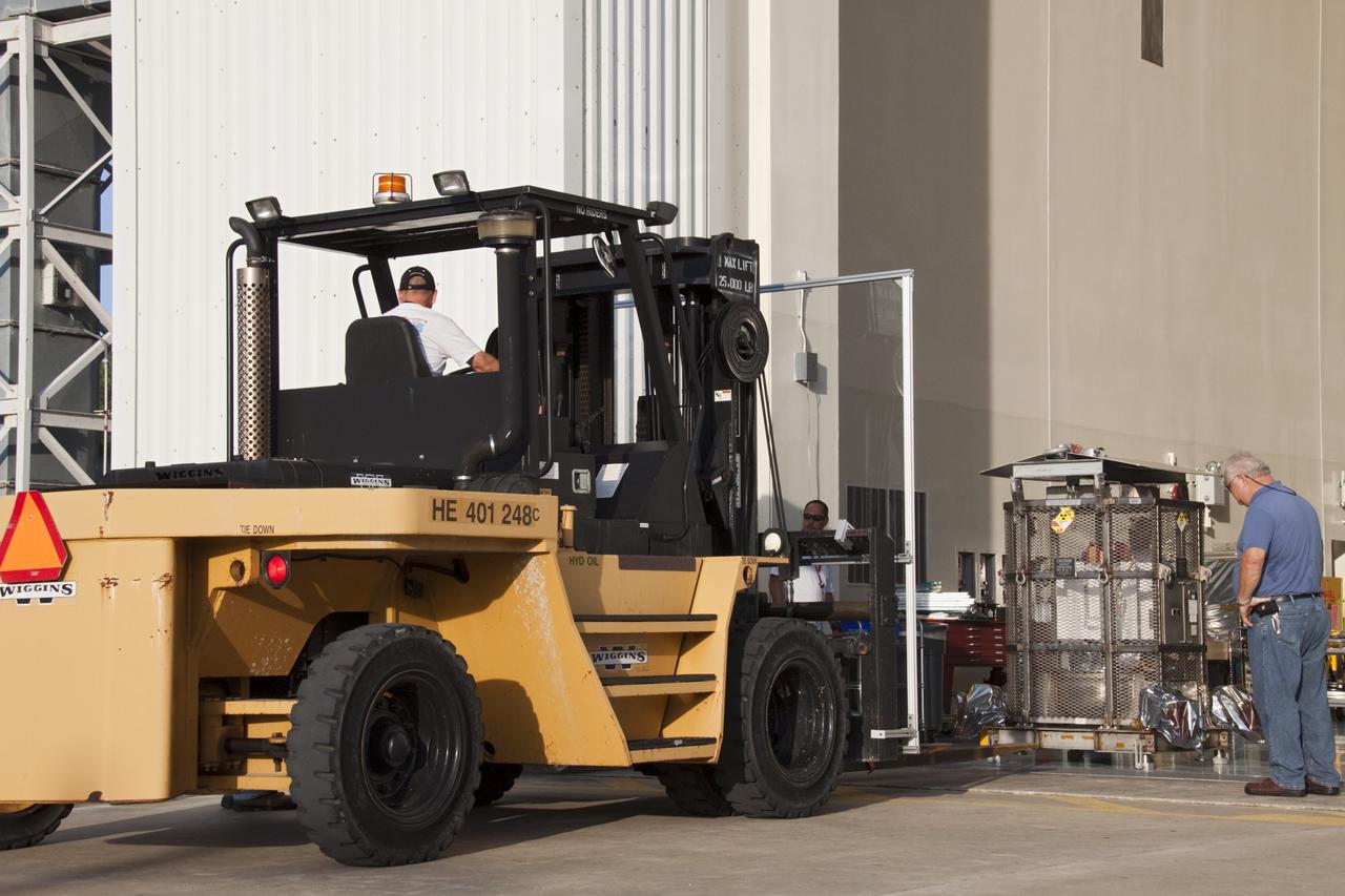 CAPE CANAVERAL, Fla. -- A forklift moves into position to lift the multi-mission radioisotope thermoelectric generator (MMRTG) for NASA's Mars Science Laboratory (MSL) mission from the floor of the Payload Hazardous Servicing Facility (PHSF) airlock at NASA's Kennedy Space Center in Florida. The MMRTG is enclosed in a mesh container, known as the "gorilla cage," which protects it during transport and allows any excess heat generated to dissipate into the air.  The MMRTG is being transported to the RTG storage facility following a fit check on MSL's Curiosity rover in the PHSF.    The MMRTG will generate the power needed for the mission from the natural decay of plutonium-238, a non-weapons-grade form of the radioisotope. Heat given off by this natural decay will provide constant power through the day and night during all seasons. MSL's components include a compact car-sized rover, Curiosity, which has 10 science instruments designed to search for signs of life, including methane, and help determine if the gas is from a biological or geological source. Waste heat from the MMRTG will be circulated throughout the rover system to keep instruments, computers, mechanical devices and communications systems within their operating temperature ranges. Launch of MSL aboard a United Launch Alliance Atlas V rocket is targeted for Nov. 25 from Space Launch Complex 41 on Cape Canaveral Air Force Station. For more information, visit http://www.nasa.gov/msl. Photo credit: NASA/Troy Cryder