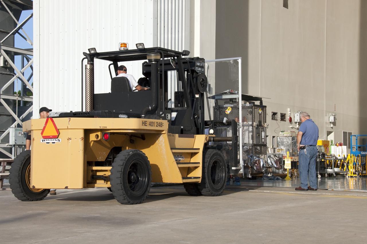 CAPE CANAVERAL, Fla. -- A forklift moves into position to lift the multi-mission radioisotope thermoelectric generator (MMRTG) for NASA's Mars Science Laboratory (MSL) mission from the floor of the Payload Hazardous Servicing Facility (PHSF) airlock at NASA's Kennedy Space Center in Florida. The MMRTG is enclosed in a mesh container, known as the "gorilla cage," which protects it during transport and allows any excess heat generated to dissipate into the air.  The MMRTG is being moved to the RTG storage facility following a fit check on MSL's Curiosity rover in the PHSF.    The MMRTG will generate the power needed for the mission from the natural decay of plutonium-238, a non-weapons-grade form of the radioisotope. Heat given off by this natural decay will provide constant power through the day and night during all seasons. MSL's components include a compact car-sized rover, Curiosity, which has 10 science instruments designed to search for signs of life, including methane, and help determine if the gas is from a biological or geological source. Waste heat from the MMRTG will be circulated throughout the rover system to keep instruments, computers, mechanical devices and communications systems within their operating temperature ranges. Launch of MSL aboard a United Launch Alliance Atlas V rocket is targeted for Nov. 25 from Space Launch Complex 41 on Cape Canaveral Air Force Station. For more information, visit http://www.nasa.gov/msl. Photo credit: NASA/Troy Cryder