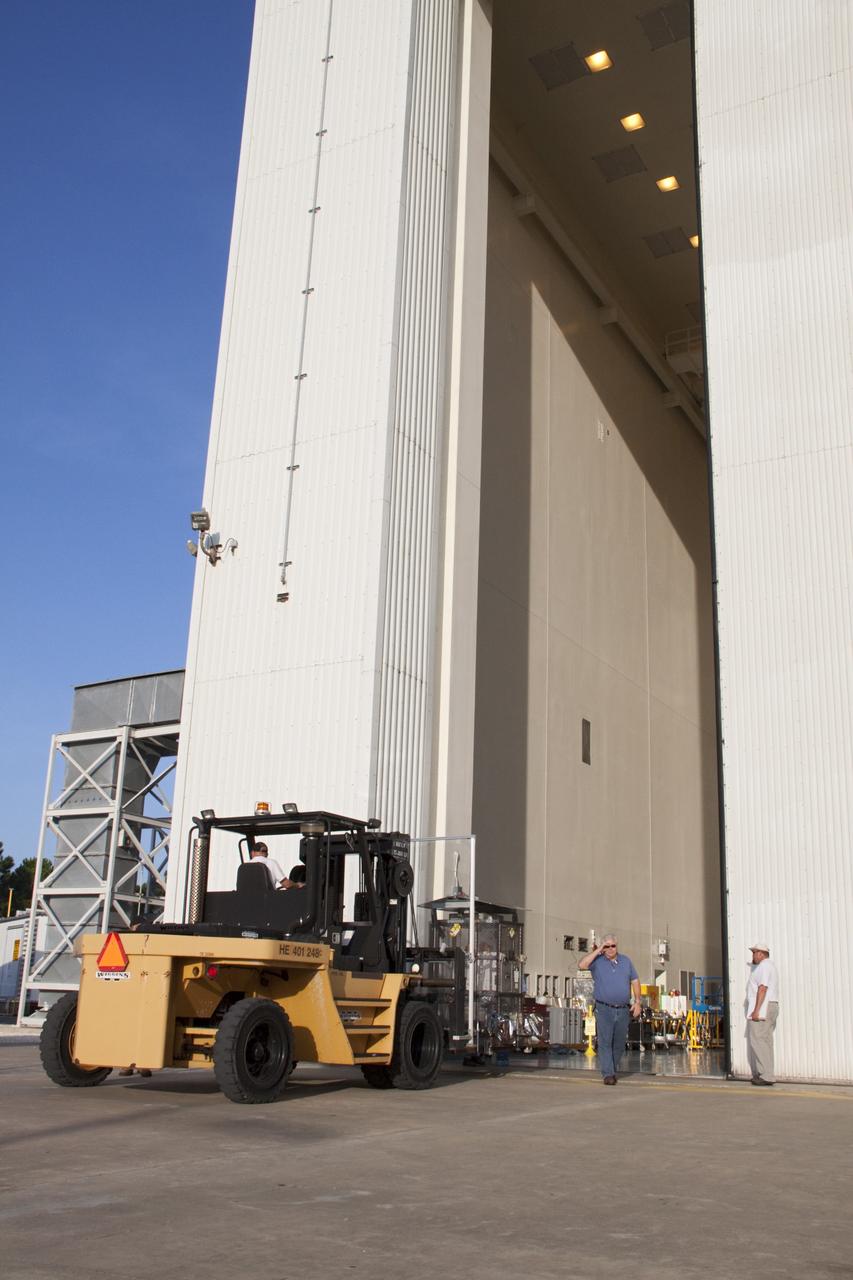 CAPE CANAVERAL, Fla. -- A forklift carrying the multi-mission radioisotope thermoelectric generator (MMRTG) for NASA's Mars Science Laboratory (MSL) mission backs away from the airlock of the Payload Hazardous Servicing Facility (PHSF) at NASA's Kennedy Space Center in Florida.  The MMRTG is enclosed in a mesh container, known as the "gorilla cage," which protects it during transport and allows any excess heat generated to dissipate into the air.  The MMRTG is being moved to the RTG storage facility following a fit check on MSL's Curiosity rover in the PHSF.    The MMRTG will generate the power needed for the mission from the natural decay of plutonium-238, a non-weapons-grade form of the radioisotope. Heat given off by this natural decay will provide constant power through the day and night during all seasons. MSL's components include a compact car-sized rover, Curiosity, which has 10 science instruments designed to search for signs of life, including methane, and help determine if the gas is from a biological or geological source. Waste heat from the MMRTG will be circulated throughout the rover system to keep instruments, computers, mechanical devices and communications systems within their operating temperature ranges. Launch of MSL aboard a United Launch Alliance Atlas V rocket is targeted for Nov. 25 from Space Launch Complex 41 on Cape Canaveral Air Force Station. For more information, visit http://www.nasa.gov/msl. Photo credit: NASA/Troy Cryder