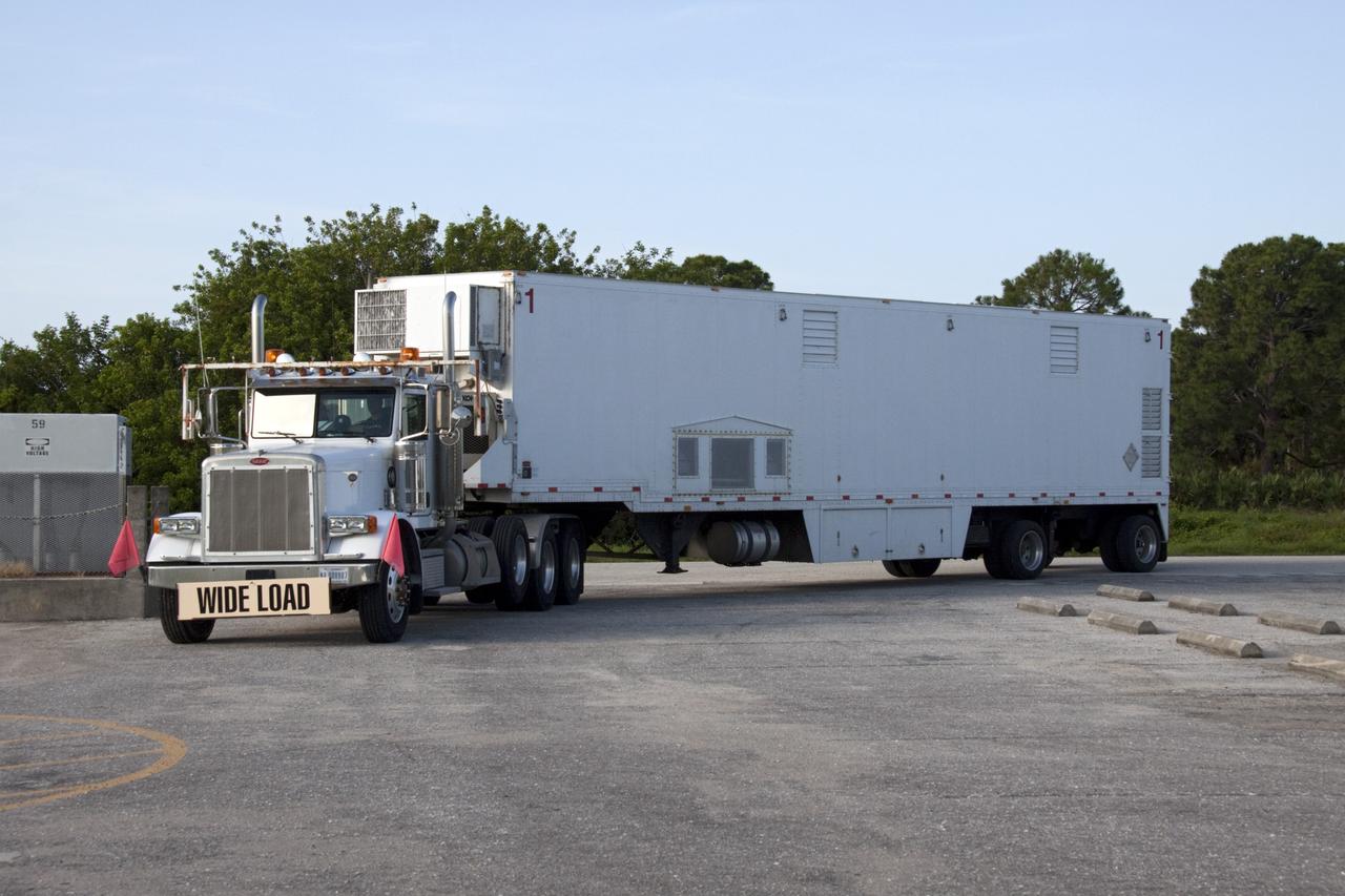 CAPE CANAVERAL, Fla. -- At NASA's Kennedy Space Center in Florida, the trailer transporting the multi-mission radioisotope thermoelectric generator (MMRTG) for NASA's Mars Science Laboratory (MSL) mission arrives at the RTG storage facility (RTGF).  The MMRTG is returning to the RTGF following a fit check on MSL's Curiosity rover in the Payload Hazardous Servicing Facility (PHSF).    The MMRTG will generate the power needed for the mission from the natural decay of plutonium-238, a non-weapons-grade form of the radioisotope. Heat given off by this natural decay will provide constant power through the day and night during all seasons. MSL's components include a compact car-sized rover, Curiosity, which has 10 science instruments designed to search for signs of life, including methane, and help determine if the gas is from a biological or geological source. Waste heat from the MMRTG will be circulated throughout the rover system to keep instruments, computers, mechanical devices and communications systems within their operating temperature ranges. Launch of MSL aboard a United Launch Alliance Atlas V rocket is targeted for Nov. 25 from Space Launch Complex 41 on Cape Canaveral Air Force Station. For more information, visit http://www.nasa.gov/msl. Photo credit: NASA/Troy Cryder