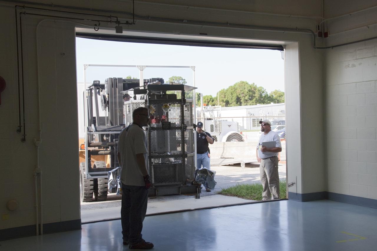 CAPE CANAVERAL, Fla. -- A forklift moves the multi-mission radioisotope thermoelectric generator (MMRTG) for NASA's Mars Science Laboratory (MSL) mission into the high bay of the RTG storage facility (RTGF) at NASA's Kennedy Space Center in Florida. The MMRTG is enclosed in a mesh container, known as the "gorilla cage," which protects it during transport and allows any excess heat generated to dissipate into the air.  The MMRTG is returning to the RTGF following a fit check on MSL's Curiosity rover in the Payload Hazardous Servicing Facility (PHSF).    The MMRTG will generate the power needed for the mission from the natural decay of plutonium-238, a non-weapons-grade form of the radioisotope. Heat given off by this natural decay will provide constant power through the day and night during all seasons. MSL's components include a compact car-sized rover, Curiosity, which has 10 science instruments designed to search for signs of life, including methane, and help determine if the gas is from a biological or geological source. Waste heat from the MMRTG will be circulated throughout the rover system to keep instruments, computers, mechanical devices and communications systems within their operating temperature ranges. Launch of MSL aboard a United Launch Alliance Atlas V rocket is targeted for Nov. 25 from Space Launch Complex 41 on Cape Canaveral Air Force Station. For more information, visit http://www.nasa.gov/msl. Photo credit: NASA/Troy Cryder