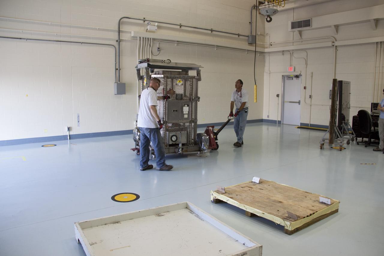 CAPE CANAVERAL, Fla. -- Department of Energy workers park the multi-mission radioisotope thermoelectric generator (MMRTG) for NASA's Mars Science Laboratory (MSL) mission in the high bay of the RTG storage facility (RTGF) at NASA's Kennedy Space Center in Florida. The MMRTG is enclosed in a mesh container, known as the "gorilla cage," which protects it during transport and allows any excess heat generated to dissipate into the air.  The MMRTG is returning to the RTGF following a fit check on MSL's Curiosity rover in the Payload Hazardous Servicing Facility (PHSF).    The MMRTG will generate the power needed for the mission from the natural decay of plutonium-238, a non-weapons-grade form of the radioisotope. Heat given off by this natural decay will provide constant power through the day and night during all seasons. MSL's components include a compact car-sized rover, Curiosity, which has 10 science instruments designed to search for signs of life, including methane, and help determine if the gas is from a biological or geological source. Waste heat from the MMRTG will be circulated throughout the rover system to keep instruments, computers, mechanical devices and communications systems within their operating temperature ranges. Launch of MSL aboard a United Launch Alliance Atlas V rocket is targeted for Nov. 25 from Space Launch Complex 41 on Cape Canaveral Air Force Station. For more information, visit http://www.nasa.gov/msl. Photo credit: NASA/Troy Cryder