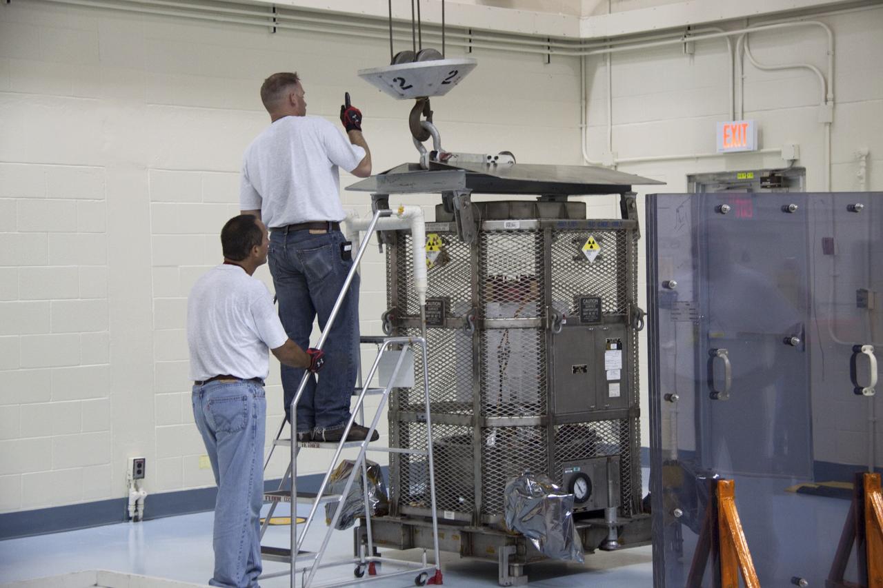CAPE CANAVERAL, Fla. -- In the high bay of the RTG storage facility (RTGF) at NASA's Kennedy Space Center in Florida, Department of Energy workers attach a crane to the mesh container enclosing the multi-mission radioisotope thermoelectric generator (MMRTG) for NASA's Mars Science Laboratory (MSL) mission. The container, known as the "gorilla cage," protects it during transport and allows any excess heat generated to dissipate into the air.  The cage is being removed from around the MMRTG following it return to the RTGF from a fit check on MSL's Curiosity rover in the Payload Hazardous Servicing Facility (PHSF).    The MMRTG will generate the power needed for the mission from the natural decay of plutonium-238, a non-weapons-grade form of the radioisotope. Heat given off by this natural decay will provide constant power through the day and night during all seasons. MSL's components include a compact car-sized rover, Curiosity, which has 10 science instruments designed to search for signs of life, including methane, and help determine if the gas is from a biological or geological source. Waste heat from the MMRTG will be circulated throughout the rover system to keep instruments, computers, mechanical devices and communications systems within their operating temperature ranges. Launch of MSL aboard a United Launch Alliance Atlas V rocket is targeted for Nov. 25 from Space Launch Complex 41 on Cape Canaveral Air Force Station. For more information, visit http://www.nasa.gov/msl. Photo credit: NASA/Troy Cryder