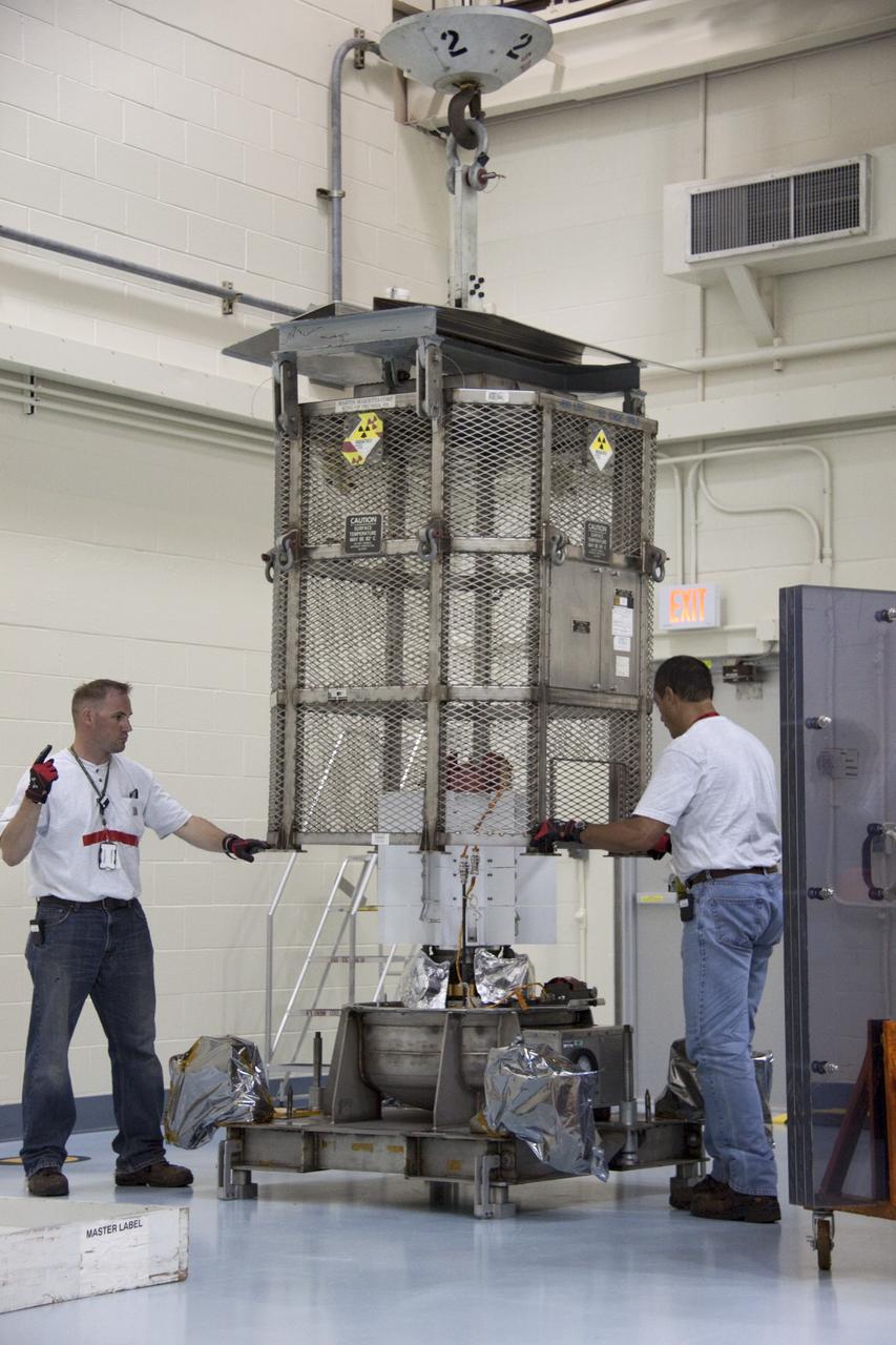 CAPE CANAVERAL, Fla. -- In the high bay of the RTG storage facility (RTGF) at NASA's Kennedy Space Center in Florida, Department of Energy workers guide the mesh container enclosing the multi-mission radioisotope thermoelectric generator (MMRTG) for NASA's Mars Science Laboratory (MSL) mission as it is lifted by a crane. The container, known as the "gorilla cage," protects the MMRTG during transport and allows any excess heat generated to dissipate into the air.  The cage is being removed from around the MMRTG following it return to the RTGF from a fit check on MSL's Curiosity rover in the Payload Hazardous Servicing Facility (PHSF).    The MMRTG will generate the power needed for the mission from the natural decay of plutonium-238, a non-weapons-grade form of the radioisotope. Heat given off by this natural decay will provide constant power through the day and night during all seasons. MSL's components include a compact car-sized rover, Curiosity, which has 10 science instruments designed to search for signs of life, including methane, and help determine if the gas is from a biological or geological source. Waste heat from the MMRTG will be circulated throughout the rover system to keep instruments, computers, mechanical devices and communications systems within their operating temperature ranges. Launch of MSL aboard a United Launch Alliance Atlas V rocket is targeted for Nov. 25 from Space Launch Complex 41 on Cape Canaveral Air Force Station. For more information, visit http://www.nasa.gov/msl. Photo credit: NASA/Troy Cryder