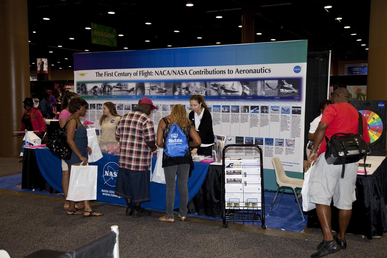 CAPE CANAVERAL, Fla. -- Education specialists at a joint exhibit from NASA's Kennedy Space Center and Glenn Research Center discuss the advancements the agency has made in aeronautics with the nationwide attendees of the Tom Joyner Family Reunion. The event was held in the Exhibit Hall of the Gaylord Palms Resort and Convention Center in Kissimmee, Fla., and hosted by nationally syndicated radio personality Tom Joyner during the extended Labor Day weekend Sept. 1-4. Besides offering attendees the opportunity to visit tourist attractions in the Orlando area, the reunion gave NASA an avenue to tout the benefits of math and scientific learning, as well as the many educational opportunities offered by the space agency. For more information on NASA's education initiatives, visit http://www.nasa.gov/education. Photo credit: NASA/Frankie Martin