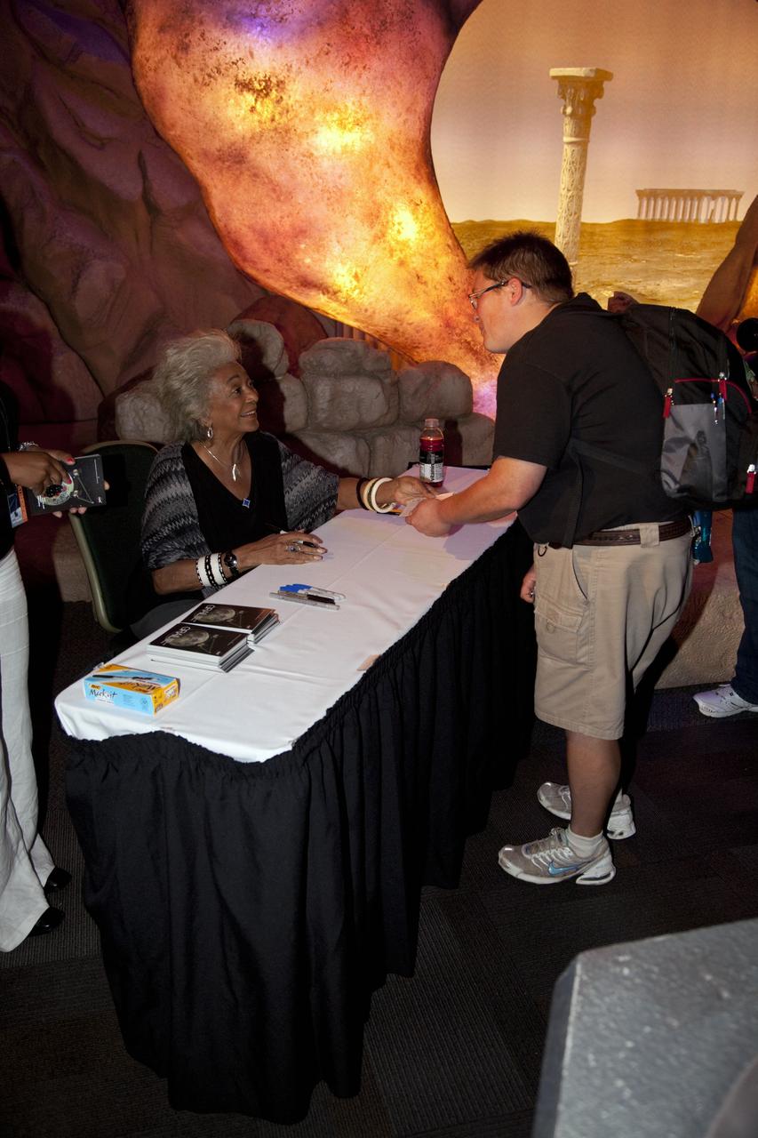 CAPE CANAVERAL, Fla. – Actress Nichelle Nichols (Lt. Uhura on Star Trek) signs autographs for a guest at the Kennedy Space Center Visitor Complex in Florida during activities for the agency’s Gravity Recovery and Interior Laboratory mission (GRAIL). Nichols was on hand to celebrate the 45th anniversary of the first airing of the Star Trek television series. The Kennedy Space Center Visitor Complex is hosting “Star Trek: The Exhibition” to show visitors where “science fiction meets science fact.”    GRAIL will fly twin spacecraft in tandem around the moon to precisely measure and map variations in the moon's gravitational field. The mission will provide the most accurate global gravity field to date for any planet, including Earth. This detailed information will reveal differences in the density of the moon's crust and mantle and will help answer fundamental questions about the moon's internal structure, thermal evolution, and history of collisions with asteroids. The aim is to map the moon's gravity field so completely that future moon vehicles can safely navigate anywhere on the moon’s surface. For more information, visit http://www.nasa.gov/grail. Photo credit: NASA/Frankie Martin