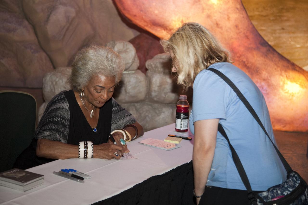 CAPE CANAVERAL, Fla. – CAPE CANAVERAL, Fla. – Actress Nichelle Nichols (Lt. Uhura on Star Trek) signs autographs for a guest at the Kennedy Space Center Visitor Complex in Florida during activities for the agency’s Gravity Recovery and Interior Laboratory mission (GRAIL). Nichols was on hand to celebrate the 45th anniversary of the first airing of the Star Trek television series. The Kennedy Space Center Visitor Complex is hosting “Star Trek: The Exhibition” to show visitors where “science fiction meets science fact.”    GRAIL will fly twin spacecraft in tandem around the moon to precisely measure and map variations in the moon's gravitational field. The mission will provide the most accurate global gravity field to date for any planet, including Earth. This detailed information will reveal differences in the density of the moon's crust and mantle and will help answer fundamental questions about the moon's internal structure, thermal evolution, and history of collisions with asteroids. The aim is to map the moon's gravity field so completely that future moon vehicles can safely navigate anywhere on the moon’s surface. For more information, visit http://www.nasa.gov/grail. Photo credit: NASA/Frankie Martin