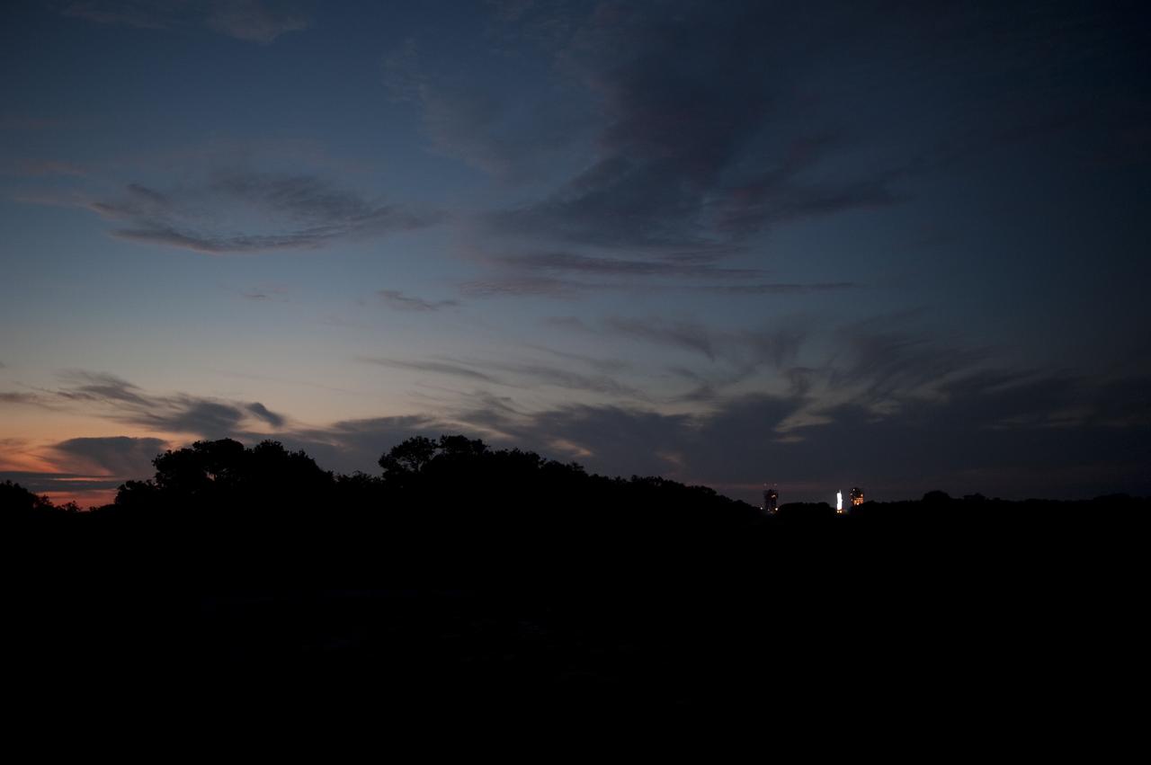 CAPE CANAVERAL, Fla. – As the sun rises, in the distance, spotlights illuminate the United Launch Alliance Delta II Heavy rocket that will launch NASA’s twin Gravity Recovery and Interior Laboratory (GRAIL) mission from Space Launch Complex 17B on Cape Canaveral Air Force Station in Florida. Liftoff is scheduled for 9:08:52 a.m. EDT Sept.10.     GRAIL will fly twin spacecraft in tandem around the moon to precisely measure and map variations in the moon's gravitational field. The mission will provide the most accurate global gravity field to date for any planet, including Earth. This detailed information will reveal differences in the density of the moon's crust and mantle and will help answer fundamental questions about the moon's internal structure, thermal evolution, and history of collisions with asteroids. The aim is to map the moon's gravity field so completely that future moon vehicles can safely navigate anywhere on the moon’s surface. For more information, visit http://www.nasa.gov/grail. Photo credit: NASA/ Kim Shiflett