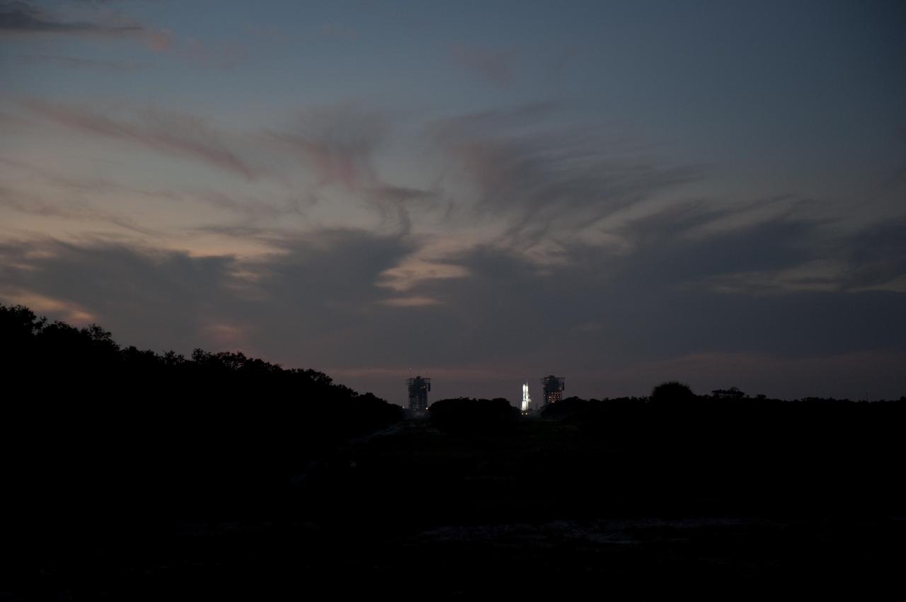 CAPE CANAVERAL, Fla. – As the sun rises, in the distance, spotlights illuminate the United Launch Alliance Delta II Heavy rocket that will launch NASA’s twin Gravity Recovery and Interior Laboratory (GRAIL) mission from Space Launch Complex 17B on Cape Canaveral Air Force Station in Florida. Liftoff is scheduled for 9:08:52 a.m. EDT Sept.10.     GRAIL will fly twin spacecraft in tandem around the moon to precisely measure and map variations in the moon's gravitational field. The mission will provide the most accurate global gravity field to date for any planet, including Earth. This detailed information will reveal differences in the density of the moon's crust and mantle and will help answer fundamental questions about the moon's internal structure, thermal evolution, and history of collisions with asteroids. The aim is to map the moon's gravity field so completely that future moon vehicles can safely navigate anywhere on the moon’s surface. For more information, visit http://www.nasa.gov/grail. Photo credit: NASA/ Kim Shiflett