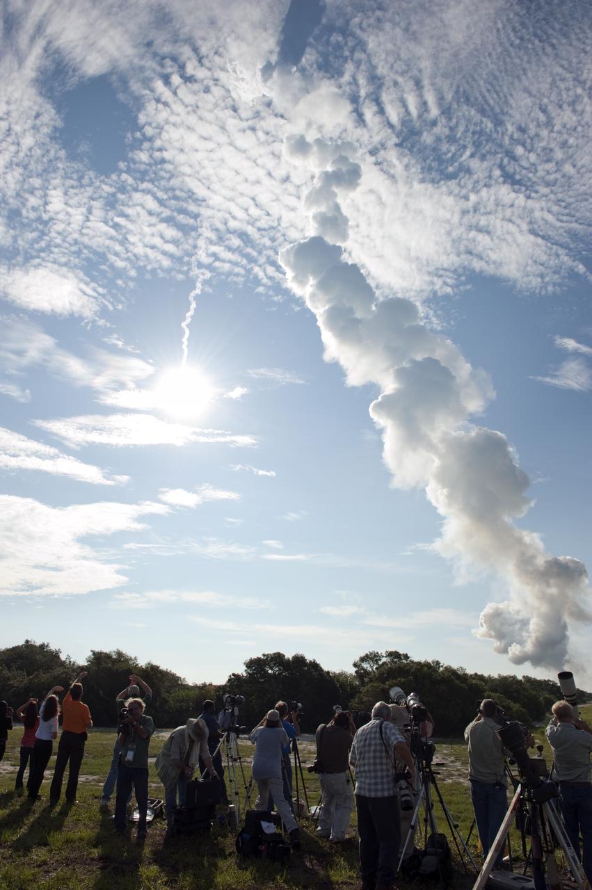CAPE CANAVERAL, Fla. – Sun reflects off the United Launch Alliance Delta II Heavy rocket launching NASA’s Gravity Recovery and Interior Laboratory (GRAIL) mission into space as media representatives at Press Site 1 near Space Launch Complex 17B on Cape Canaveral Air Force Station in Florida capture the moment. Liftoff was at 9:08:52 a.m. EDT Sept.10. GRAIL-A will separate from the second stage of the rocket at about one hour, 21 minutes after liftoff, followed by GRAIL-B at 90 minutes after launch. The spacecraft are embarking on a three-month journey to reach the moon.    GRAIL will fly twin spacecraft in tandem around the moon to precisely measure and map variations in the moon's gravitational field. The mission will provide the most accurate global gravity field to date for any planet, including Earth. This detailed information will reveal differences in the density of the moon's crust and mantle and will help answer fundamental questions about the moon's internal structure, thermal evolution, and history of collisions with asteroids. The aim is to map the moon's gravity field so completely that future moon vehicles can safely navigate anywhere on the moon’s surface. For more information, visit http://www.nasa.gov/grail. Photo credit: NASA/ Kim Shiflett
