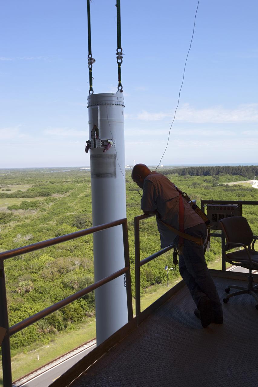 CAPE CANAVERAL, Fla. – A technician at the Vertical Integration Facility at Space Launch Complex 41 on Cape Canaveral Air Force Station in Florida monitors the lifting of a solid rocket motor (SRM) for mating to a United Launch Alliance Atlas V rocket which will carry NASA's Mars Science Laboratory (MSL) mission.    MSL's components include a compact car-sized rover, Curiosity, which has 10 science instruments designed to search for evidence on whether Mars has had environments favorable to microbial life, including chemical ingredients for life.  The unique rover will use a laser to look inside rocks and release its gasses so that the rover’s spectrometer can analyze and send the data back to Earth. MSL is scheduled to launch Nov. 25 with a window extending to Dec. 18 and arrival at Mars Aug. 2012. For more information, visit http://www.nasa.gov/msl. Photo credit: NASA/Dimitri Gerondidakis