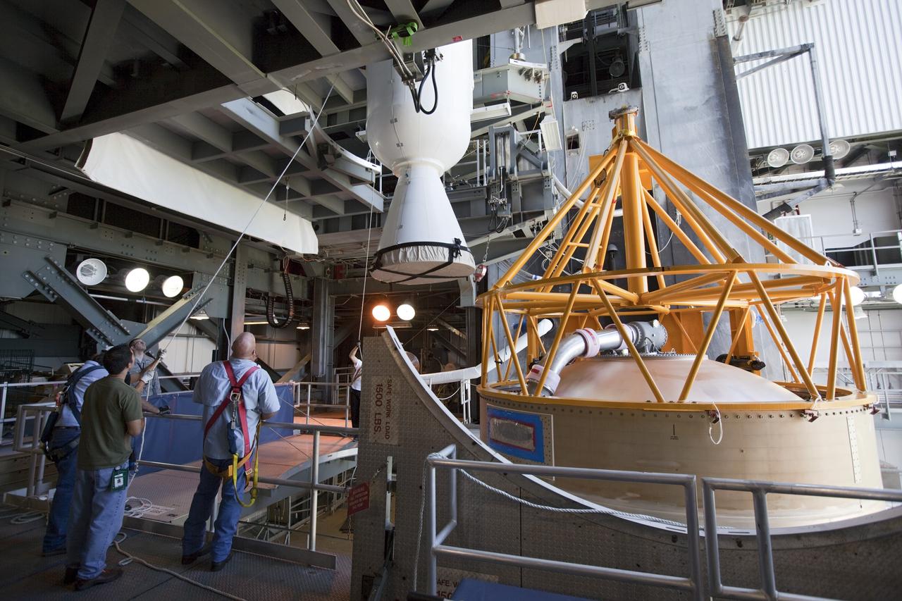 CAPE CANAVERAL, Fla. – Inside the Vertical Integration Facility at Space Launch Complex 41 on Cape Canaveral Air Force Station in Florida, technicians monitor the progress as a crane lowers a solid rocket motor (SRM) for mating to the first stage of a United Launch Alliance Atlas V rocket. The Atlas V will carry NASA's Mars Science Laboratory (MSL) mission into space. MSL's components include a compact car-sized rover, Curiosity, which has 10 science instruments designed to search for evidence on whether Mars has had environments favorable to microbial life, including chemical ingredients for life. The unique rover will use a laser to look inside rocks and release its gasses so that the rover’s spectrometer can analyze and send the data back to Earth. MSL is scheduled to launch Nov. 25 with a window extending to Dec. 18 and arrival at Mars Aug. 2012. For more information, visit http://www.nasa.gov/msl. Photo credit: NASA/Dimitri Gerondidakis