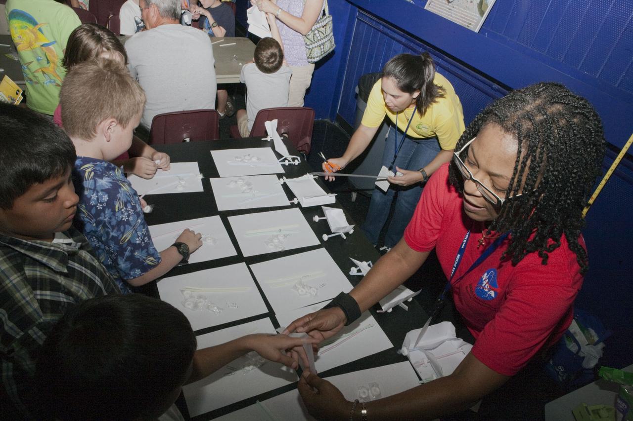 CAPE CANAVERAL, Fla. – Education specialists help children participation in educational activities during Family Night, Sept. 10, at Kennedy Space Center’s U.S. Astronaut Hall of Fame in Florida.    NASA and the Kennedy Space Center Visitor Complex hosted the annual NASA family education night. The event, for fifth- through eighth-grade students and their parents, focuses on science, technology, engineering and mathematics (STEM) education activities that included astronaut appearances, a hovercraft, vortex cannon and alternative fuel vehicles. The back-to-school event is part of NASA’s Summer of Innovation initiative to provide interactive learning experiences to middle school students nationwide.  Photo credit: NASA/Amanda Diller