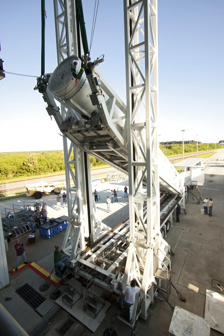 CAPE CANAVERAL, Fla. – With a view taken from inside the Vertical Integration Facility at Space Launch Complex 41 on Cape Canaveral Air Force Station in Florida, technicians use a lifting device to elevate the final solid rocket motor (SRM) into an upright position for mating to a United Launch Alliance Atlas V rocket which will carry NASA's Mars Science Laboratory (MSL) mission.     MSL's components include a compact car-sized rover, Curiosity, which has 10 science instruments designed to search for evidence on whether Mars has had environments favorable to microbial life, including chemical ingredients for life.  The unique rover will use a laser to look inside rocks and release its gasses so that the rover’s spectrometer can analyze and send the data back to Earth. MSL is scheduled to launch Nov. 25 with a window extending to Dec. 18 and arrival at Mars Aug. 2012. For more information, visit http://www.nasa.gov/msl. Photo credit: NASA/Jim Grossmann