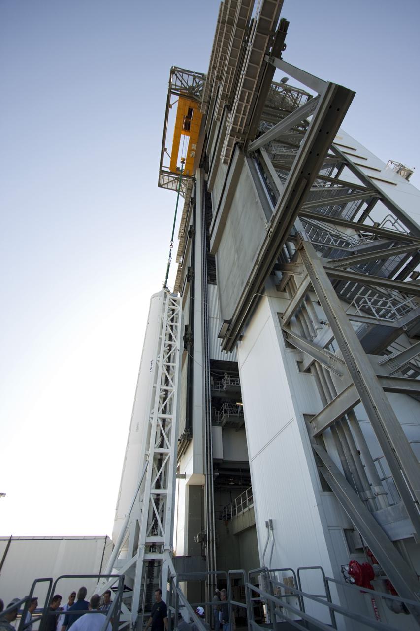 CAPE CANAVERAL, Fla. – With a side view of the Vertical Integration Facility at Space Launch Complex 41 on Cape Canaveral Air Force Station in Florida, technicians  monitor nearby as the final solid rocket motor (SRM) hangs in an upright position for mating to a United Launch Alliance Atlas V rocket which will carry NASA's Mars Science Laboratory (MSL) mission.     MSL's components include a compact car-sized rover, Curiosity, which has 10 science instruments designed to search for evidence on whether Mars has had environments favorable to microbial life, including chemical ingredients for life.  The unique rover will use a laser to look inside rocks and release its gasses so that the rover’s spectrometer can analyze and send the data back to Earth. MSL is scheduled to launch Nov. 25 with a window extending to Dec. 18 and arrival at Mars Aug. 2012. For more information, visit http://www.nasa.gov/msl. Photo credit: NASA/Jim Grossmann
