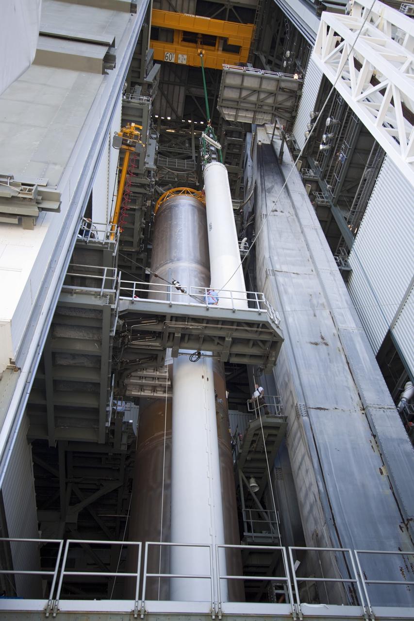 CAPE CANAVERAL, Fla. – Inside the Vertical Integration Facility at Space Launch Complex 41 on Cape Canaveral Air Force Station in Florida, a crane positions the final solid rocket motor (SRM) for mating to the first stage of a United Launch Alliance Atlas V rocket. The Atlas V will carry NASA's Mars Science Laboratory (MSL) mission into space. MSL's components include a compact car-sized rover, Curiosity, which has 10 science instruments designed to search for evidence on whether Mars has had environments favorable to microbial life, including chemical ingredients for life. The unique rover will use a laser to look inside rocks and release its gasses so that the rover’s spectrometer can analyze and send the data back to Earth. MSL is scheduled to launch Nov. 25 with a window extending to Dec. 18 and arrival at Mars Aug. 2012. For more information, visit http://www.nasa.gov/msl. Photo credit: NASA/Jim Grossmann