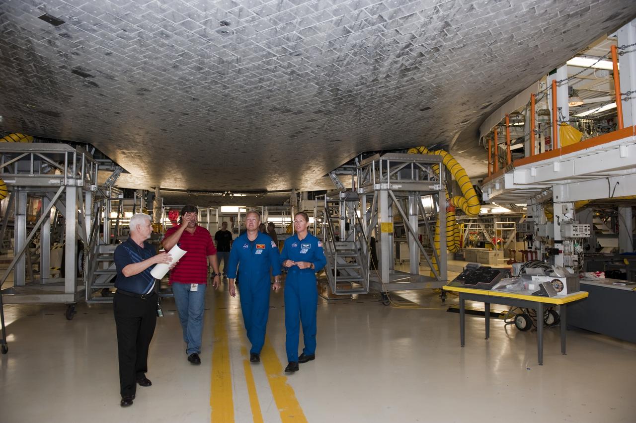 CAPE CANAVERAL, Fla. – STS-135 Pilot Doug Hurley and Mission Specialist Sandra Magnus receive a briefing and up-close look beneath space shuttle Atlantis inside Kennedy Space Center's Orbiter Processing Facility-2. Atlantis is being prepared for eventual display at the Kennedy Space Center Visitor Complex in Florida. The astronauts, along Commander Chris Ferguson, were at the center for the traditional post-flight crew return presentation.    STS-135 Mission Specialist Rex Walheim was unable to attend the Kennedy event. In July 2011, Atlantis and its crew delivered to the International Space Station the Raffaello multi-purpose logistics module packed with more than 9,400 pounds of spare parts, equipment and supplies that will sustain station operations for the next year. STS-135 was the 33rd and final flight for Atlantis and the final mission of the Space Shuttle Program. For more information, visit www.nasa.gov/mission_pages/shuttle/shuttlemissions/sts135/index.html. Photo credit: NASA/Kim Shiflett