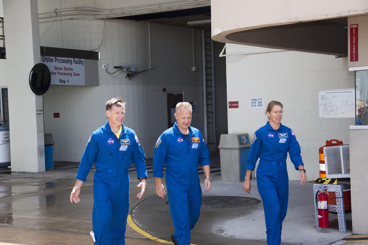 CAPE CANAVERAL, Fla. – Astronauts from space shuttle Atlantis’ STS-135 mission leave Kennedy Space Center's Orbiter Processing Facility-2 after visiting with employees. From left are Commander Chris Ferguson, Pilot Doug Hurley and Mission Specialist Sandra Magnus. The astronauts were at the center for the traditional post-flight crew return presentation.    STS-135 Mission Specialist Rex Walheim was unable to attend the Kennedy event. In July 2011, Atlantis and its crew delivered to the International Space Station the Raffaello multi-purpose logistics module packed with more than 9,400 pounds of spare parts, equipment and supplies that will sustain station operations for the next year. STS-135 was the 33rd and final flight for Atlantis and the final mission of the Space Shuttle Program. For more information, visit www.nasa.gov/mission_pages/shuttle/shuttlemissions/sts135/index.html. Photo credit: NASA/Jim Grossmann
