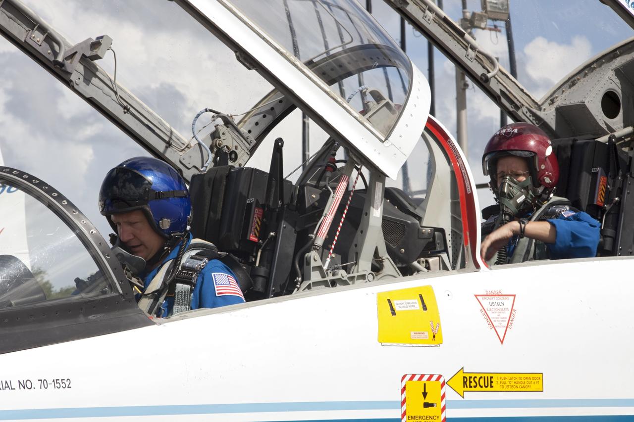 CAPE CANAVERAL, Fla. – At the Shuttle Landing Facility at NASA's Kennedy Space Center in Florida, STS-135 Pilot Doug Hurley and Mission Specialist Sandra Magnus (in the red helmet) prepare for departure in a T-38 training jet. The astronauts, along with Commander Chris Ferguson, were at the center for the traditional post-flight crew return presentation. STS-135 Mission Specialist Rex Walheim was unable to attend the Kennedy event. In July 2011, Atlantis and its crew delivered to the International Space Station the Raffaello multi-purpose logistics module packed with more than 9,400 pounds of spare parts, equipment and supplies that will sustain station operations for the next year. STS-135 was the 33rd and final flight for Atlantis and the final mission of the Space Shuttle Program. For more information, visit www.nasa.gov/mission_pages/shuttle/shuttlemissions/sts135/index.html. Photo credit: NASA/Jim Grossmann