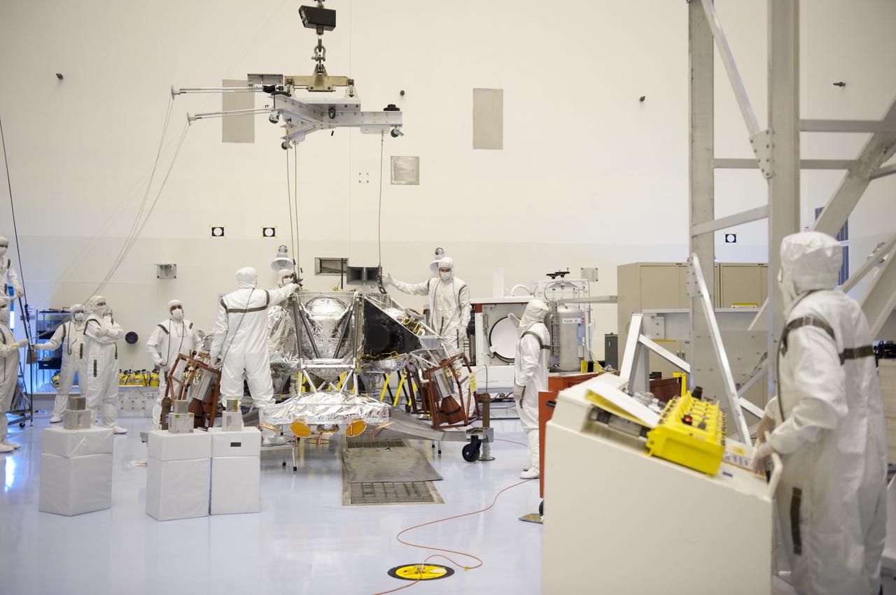 CAPE CANAVERAL, Fla. – At the Payload Hazardous Servicing Facility at NASA’s Kennedy Space Center in Florida, technicians dressed in clean room attire, known as "bunny" suits, attach an overhead crane to a rocket-powered descent stage preparing for integration with NASA's Mars Science Laboratory (MSL) rover, known as Curiosity. The descent stage will lower Curiosity to the surface of Mars. A United Launch Alliance Atlas V-541 configuration will be used to loft MSL into space. Curiosity’s 10 science instruments are designed to search for evidence on whether Mars has had environments favorable to microbial life, including chemical ingredients for life. The unique rover will use a laser to look inside rocks and release its gasses so that the rover’s spectrometer can analyze and send the data back to Earth. MSL is scheduled to launch Nov. 25 with a window extending to Dec. 18 and arrival at Mars Aug. 2012. For more information, visit http://www.nasa.gov/msl. Photo credit: NASA/Kim Shiflett