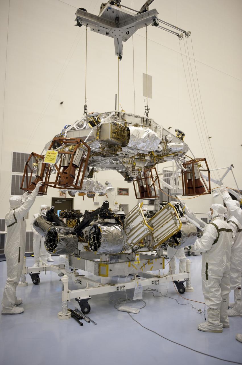 CAPE CANAVERAL, Fla. – Technicians at the Payload Hazardous Servicing Facility at NASA's Kennedy Space Center in Florida, guide an overhead crane as it lowers a rocket-powered descent stage over NASA's Mars Science Laboratory (MSL) rover, known as Curiosity, for integration. The descent stage will lower Curiosity to the surface of Mars.     A United Launch Alliance Atlas V-541 configuration will be used to loft MSL into space. Curiosity’s 10 science instruments are designed to search for evidence on whether Mars has had environments favorable to microbial life, including chemical ingredients for life.  The unique rover will use a laser to look inside rocks and release its gasses so that the rover’s spectrometer can analyze and send the data back to Earth. MSL is scheduled to launch Nov. 25 with a window extending to Dec. 18 and arrival at Mars Aug. 2012. For more information, visit http://www.nasa.gov/msl. Photo credit: NASA/Kim Shiflett