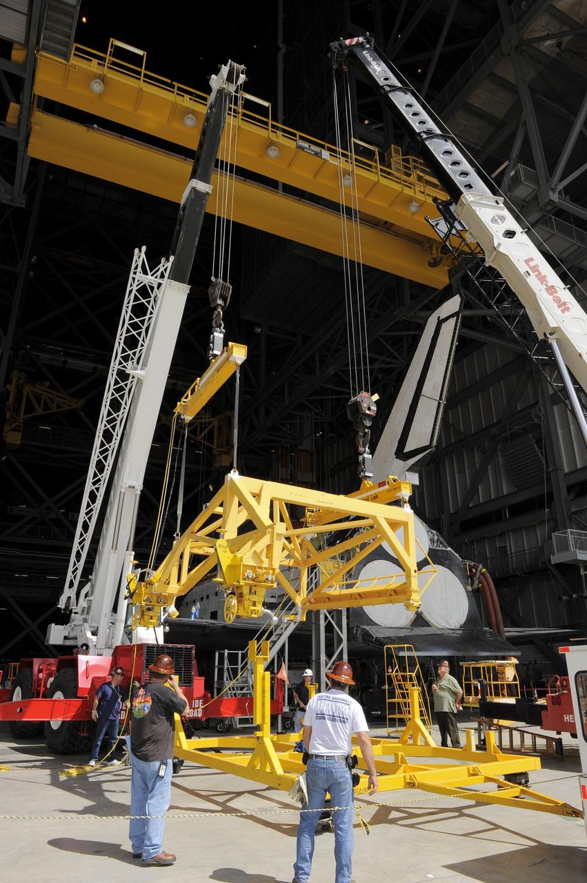 CAPE CANAVERAL, Fla. – In the Vehicle Assembly Building at NASA's Kennedy Space Center in Florida, workers, using overhead cranes, raise a cage which will be placed over an Approach and Landing Test Assembly (ALTA) pod. The ALTA pod will be lifted for attachment to space shuttle Endeavour on the site once housing the orbital maneuvering system (OMS) pod. The demonstration test is being conducted to ensure the center’s equipment will fit into the hangar at the National Air and Space Museum when installing an ALTA pod on shuttle Enterprise. The pod must be reinstalled on a shuttle for transport on a 747 carrier aircraft. The simulation also tests procedures and timelines necessary to carry out the process.       The work is part of the Space Shuttle Program’s transition and retirement processing. Enterprise, which was not equipped for space flight, was built as a test vehicle to demonstrate that the orbiter could fly in the atmosphere and land like an airplane. In 1985, Enterprise was ferried from the Kennedy Space Center to Dulles Airport, Washington, D.C., and became the property of the Smithsonian Institute. Enterprise will be moved from the Smithsonian Institution National Air and Space Museum's Steven F. Udvar-Hazy Center in Chantilly, Va., to the Intrepid Sea, Air and Space Museum in New York. For more information, visit http://www.nasa.gov/shuttle. Photo credit: NASA/Ken Shiflett