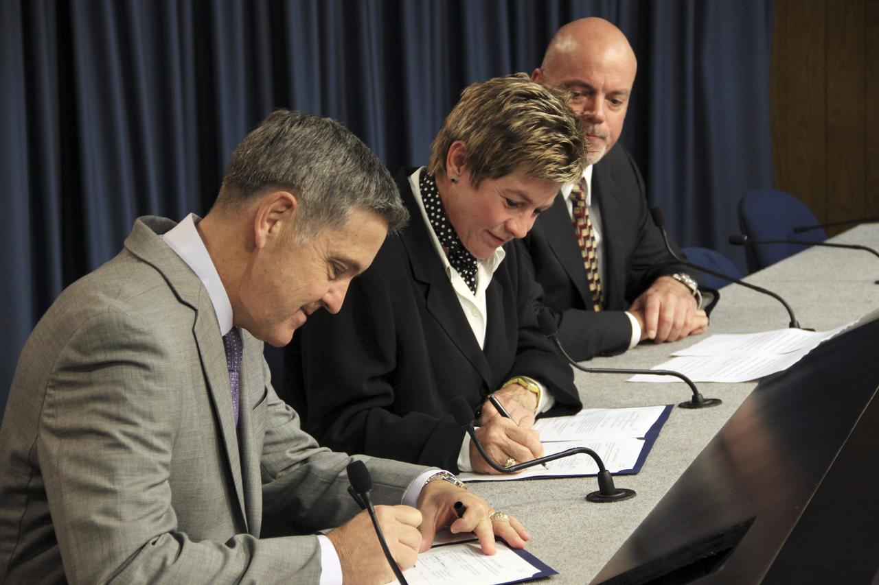 CAPE CANAVERAL, Fla. -- In the Press Site auditorium at NASA's Kennedy Space Center in Florida, representatives of NASA and the Economic Development Commission (EDC) of Florida’s Space Coast sign a new five-year Space Act Agreement. From left are Kennedy Space Center Director Director Robert Cabana and EDC President and CEO Lynda Weatherman, with Chairman of the Board of the EDC Bob Whelen looking on.      The agreement calls for NASA and EDC senior leadership to meet regularly to discuss economic development matters of mutual interest. Managers from Kennedy’s Center Planning and Development Office will work with the EDC on potential business partnerships and meet with business leaders and committees to address space-related and high-tech economic development. EDC officials will assist NASA with disseminating information about potential partnership opportunities, as well as space-related and high-tech economic development, and increase awareness of Kennedy’s Engineering and Technology Directorate collaboration initiatives. They also will promote the commercial use of underutilized facilities at Kennedy. NASA and the EDC entered into their first economic cooperation agreement in 2005.  For more information about the Economic Development Commission (EDC) of Florida’s Space Coast, visit http://www.spacecoastedc.org/. Photo credit: NASA/Jim Grossmann