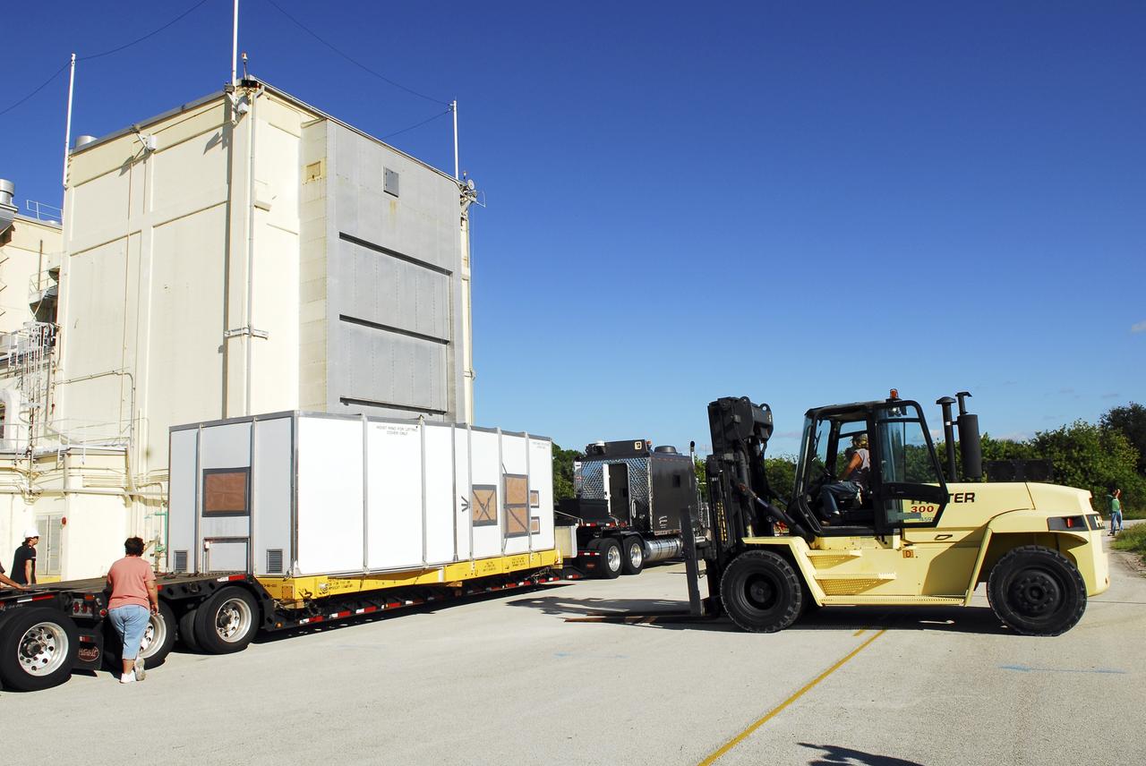 CAPE CANAVERAL, Fla. – Workers outside the Hypergol Maintenance Facility at NASA’s Kennedy Space Center in Florida use a forklift to elevate a shipping crate, containing space shuttle Discovery's orbital maneuvering system (OMS) pod, off a flatbed truck. The OMS has been returned from White Sands Space Harbor in New Mexico where it underwent a complete deservicing and cleaning.        The work is part of the Space Shuttle Program’s transition and retirement processing of space shuttle Discovery. The shuttle will go to the Smithsonian's National Air and Space Museum, Steven F. Udvar-Hazy Center in Chantilly, Va. For more information, visit http://www.nasa.gov/shuttle. Photo credit: NASA/Jim Grossmann