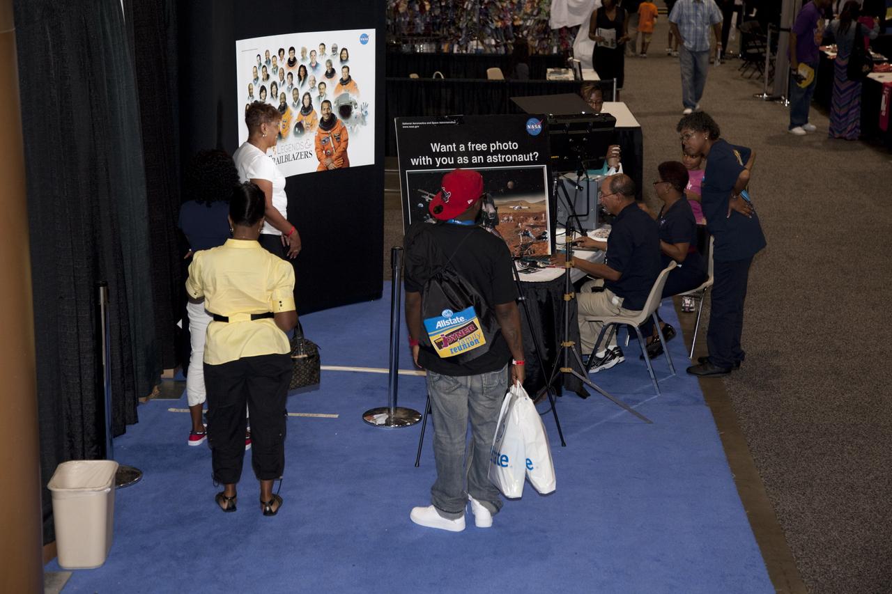 CAPE CANAVERAL, Fla. -- Attendees of the Tom Joyner Family Reunion wait their turns to have photos taken that will make them appear to be dressed in space suits. The reunion was held in the Exhibit Hall of the Gaylord Palms Resort and Convention Center in Kissimmee, Fla., and hosted by nationally syndicated radio personality Tom Joyner during the extended Labor Day weekend Sept. 1-4. Besides offering attendees the opportunity to visit tourist attractions in the Orlando area, the event gave NASA education specialists an avenue to tout the benefits of math and scientific learning, as well as the many educational opportunities offered by the space agency. For more information on NASA's education initiatives, visit http://www.nasa.gov/education. Photo credit: NASA/Frankie Martin