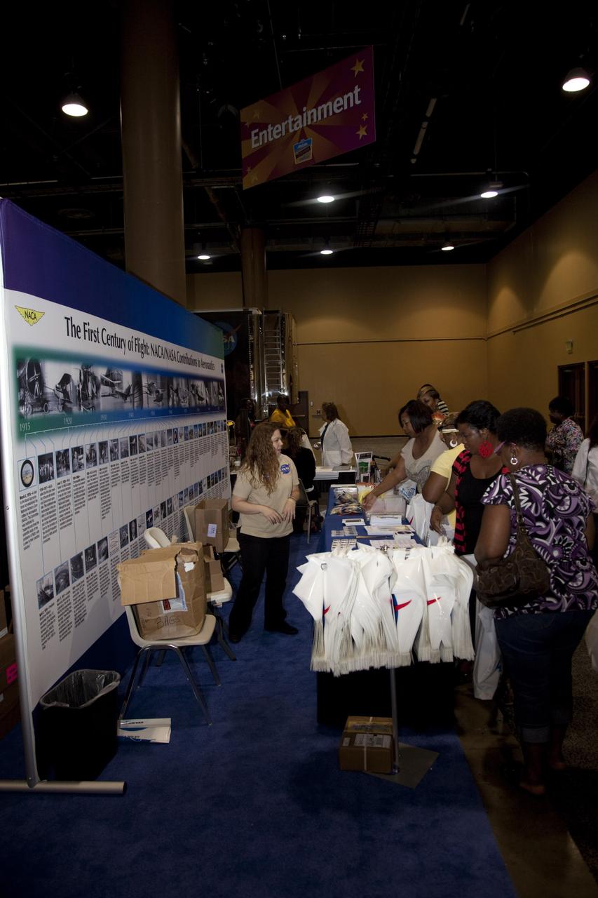 CAPE CANAVERAL, Fla. -- Education specialists at a joint exhibit from NASA's Kennedy Space Center and Glenn Research Center discuss the advancements the agency has made in aeronautics with the nationwide attendees of the Tom Joyner Family Reunion. The event was held in the Exhibit Hall of the Gaylord Palms Resort and Convention Center in Kissimmee, Fla., and hosted by nationally syndicated radio personality Tom Joyner during the extended Labor Day weekend Sept. 1-4. Besides offering attendees the opportunity to visit tourist attractions in the Orlando area, the reunion gave NASA an avenue to tout the benefits of math and scientific learning, as well as the many educational opportunities offered by the space agency. For more information on NASA's education initiatives, visit http://www.nasa.gov/education. Photo credit: NASA/Frankie Martin