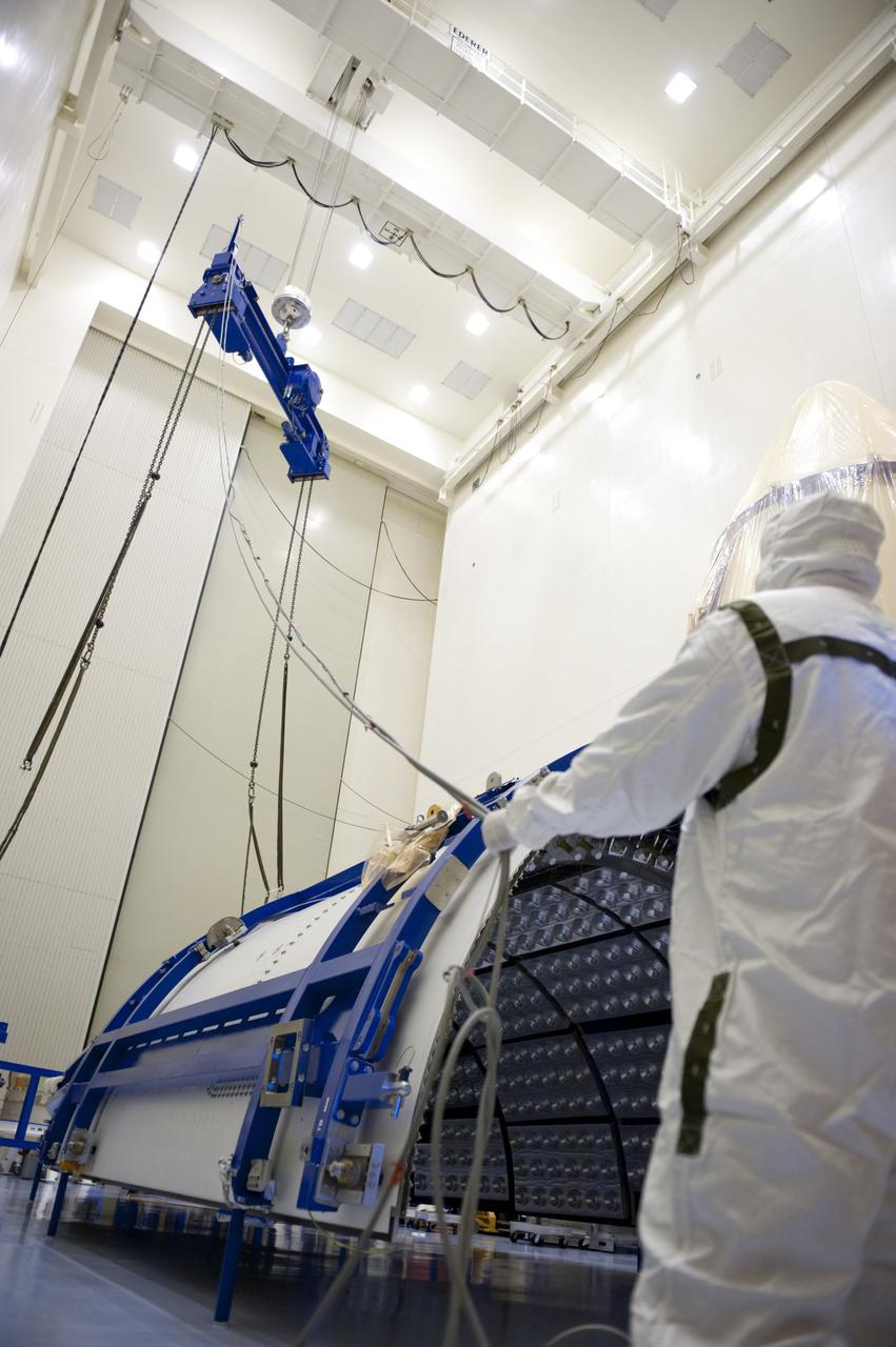 CAPE CANAVERAL, Fla. -- In the Payload Hazardous Servicing Facility at NASA's Kennedy Space Center in Florida, United Launch Alliance technicians lower a lifting device toward half of the Atlas V payload fairing for NASA's Mars Science Laboratory (MSL) mission. The fairing has been uncovered, and preparations are under way to clean it to meet NASA's planetary protection requirements. The fairing will protect the spacecraft from the impact of aerodynamic pressure and heating during ascent. Although jettisoned once the spacecraft is outside the Earth's atmosphere, the fairing must be cleaned to the same exacting standards as the laboratory to avoid the possibility of contaminating it. MSL's components include a compact car-sized rover, Curiosity, which has 10 science instruments designed to search for evidence on whether Mars has had environments favorable to microbial life, including the chemical ingredients for life. The unique rover will use a laser to look inside rocks and release its gasses so that the rover’s spectrometer can analyze and send the data back to Earth. Launch of MSL aboard a United Launch Alliance Atlas V rocket is planned for Nov. 25 from Space Launch Complex 41 on Cape Canaveral Air Force Station. For more information, visit http://www.nasa.gov/msl. Photo credit: NASA/Kim Shiflett