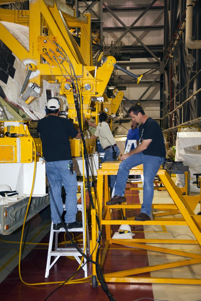 CAPE CANAVERAL, Fla. – In Orbiter Processing Facility-1 at NASA’s Kennedy Space Center in Florida, technicians assist as a crane is secured around an orbital maneuvering system (OMS) pod that will be installed on space shuttle Discovery.    The OMS pod was returned from White Sands Space Harbor in New Mexico where it underwent a complete deservicing and cleaning. The work is part of the Space Shuttle Program’s transition and retirement processing of space shuttle Discovery. The shuttle will go to the Smithsonian’s National Air and Space Museum, Steven F. Udvar-Hazy Center in Chantilly, Va., in April 2012. For more information, visit http://www.nasa.gov/shuttle.  Photo credit: NASA/Frankie Martin