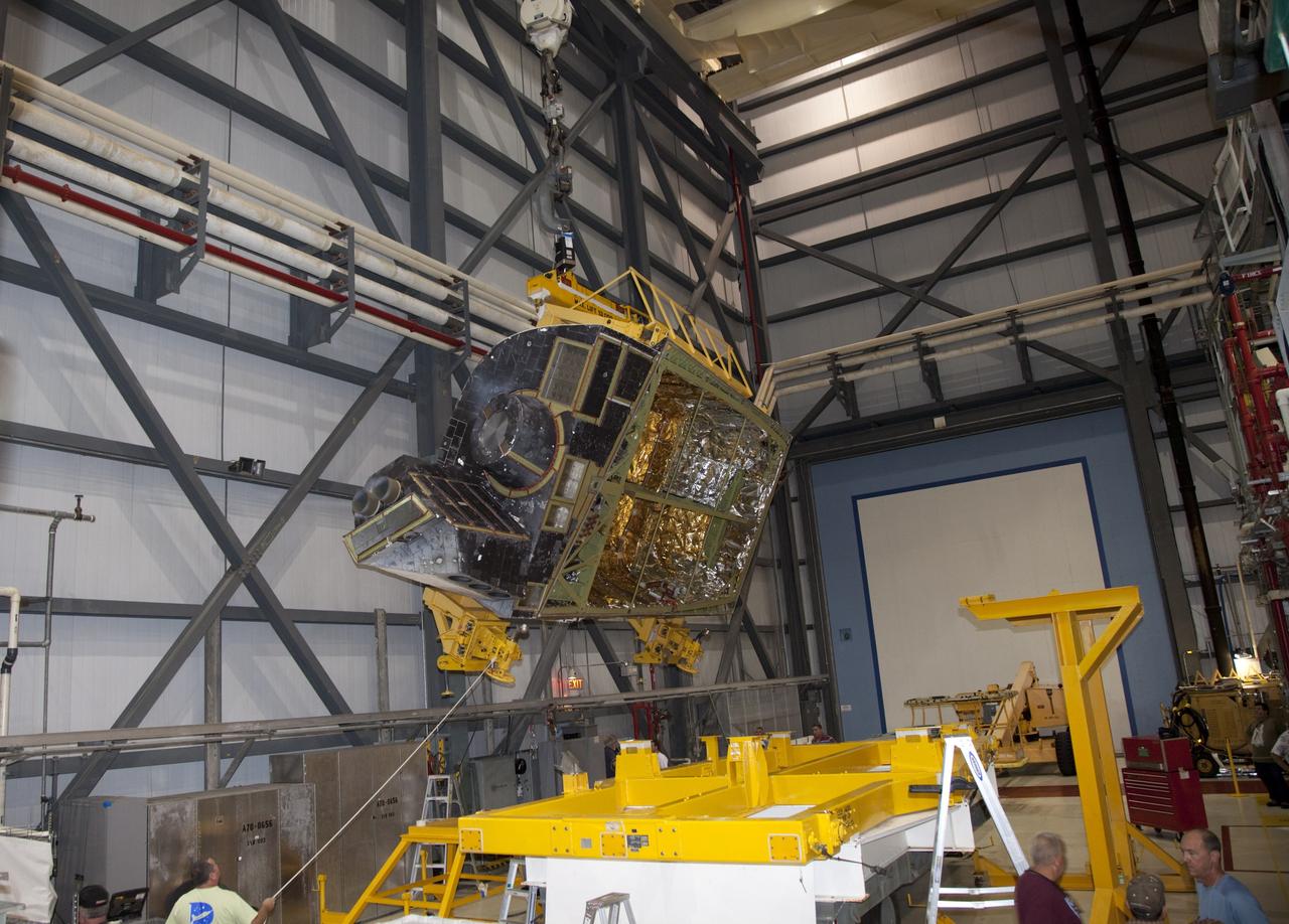 CAPE CANAVERAL, Fla. – In Orbiter Processing Facility-1 at NASA’s Kennedy Space Center in Florida, technicians monitor the progress as a crane is used to carry an orbital maneuvering system (OMS) pod that will be installed on space shuttle Discovery.    The OMS pod was returned from White Sands Space Harbor in New Mexico where it underwent a complete deservicing and cleaning. The work is part of the Space Shuttle Program’s transition and retirement processing of space shuttle Discovery. The shuttle will go to the Smithsonian’s National Air and Space Museum, Steven F. Udvar-Hazy Center in Chantilly, Va., in April 2012. For more information, visit http://www.nasa.gov/shuttle.  Photo credit: NASA/Frankie Martin