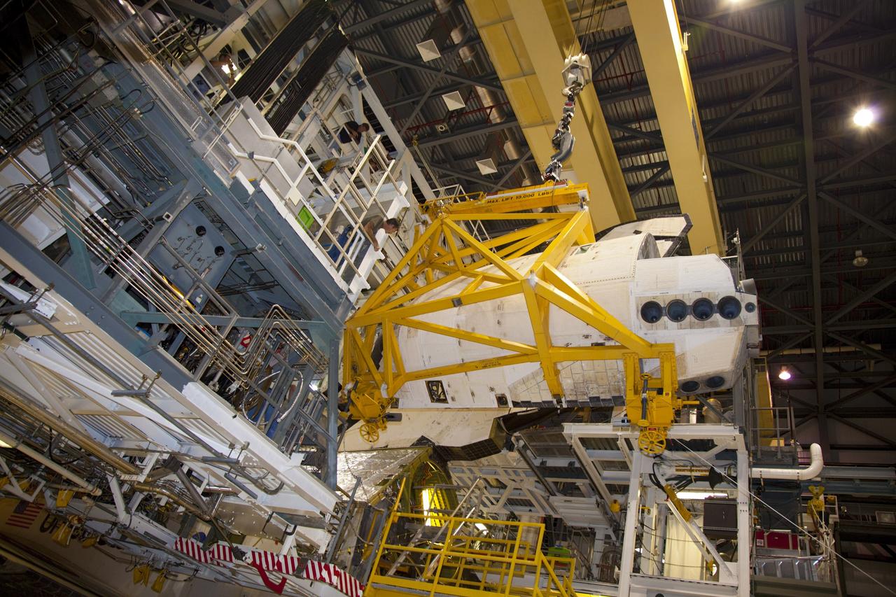 CAPE CANAVERAL, Fla. – In Orbiter Processing Facility-1 at NASA’s Kennedy Space Center in Florida, a crane carries an orbital maneuvering system (OMS) pod closer to space shuttle Discovery. The OMS pod will be installed on Discovery.     The OMS pod was returned from White Sands Space Harbor in New Mexico where it underwent a complete deservicing and cleaning. The work is part of the Space Shuttle Program’s transition and retirement processing of space shuttle Discovery. The shuttle will go to the Smithsonian’s National Air and Space Museum, Steven F. Udvar-Hazy Center in Chantilly, Va., in April 2012. For more information, visit http://www.nasa.gov/shuttle.  Photo credit: NASA/Frankie Martin