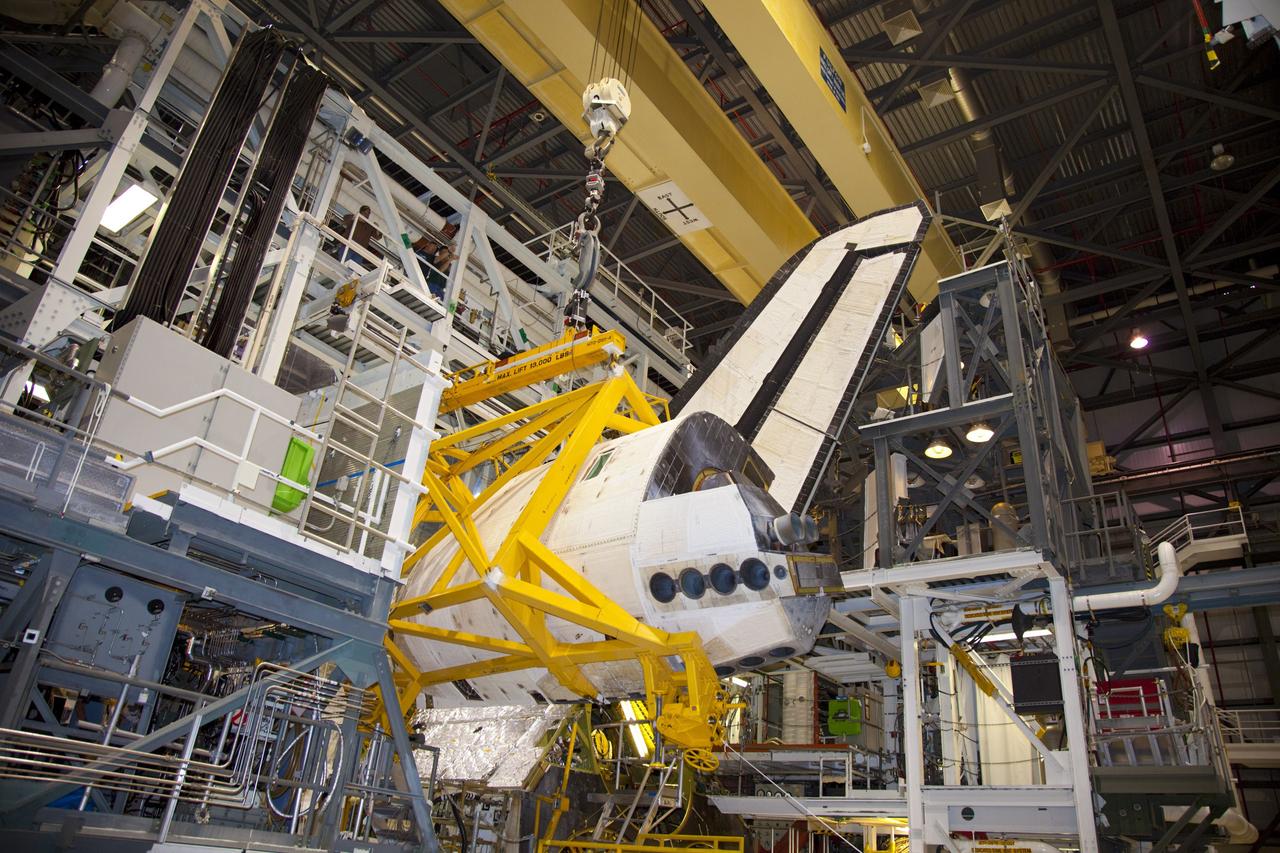 CAPE CANAVERAL, Fla. – In Orbiter Processing Facility-1 at NASA’s Kennedy Space Center in Florida, a crane carries an orbital maneuvering system (OMS) pod closer to space shuttle Discovery. The OMS pod will be installed on Discovery.     The OMS pod was returned from White Sands Space Harbor in New Mexico where it underwent a complete deservicing and cleaning. The work is part of the Space Shuttle Program’s transition and retirement processing of space shuttle Discovery. The shuttle will go to the Smithsonian’s National Air and Space Museum, Steven F. Udvar-Hazy Center in Chantilly, Va., in April 2012. For more information, visit http://www.nasa.gov/shuttle.  Photo credit: NASA/Frankie Martin