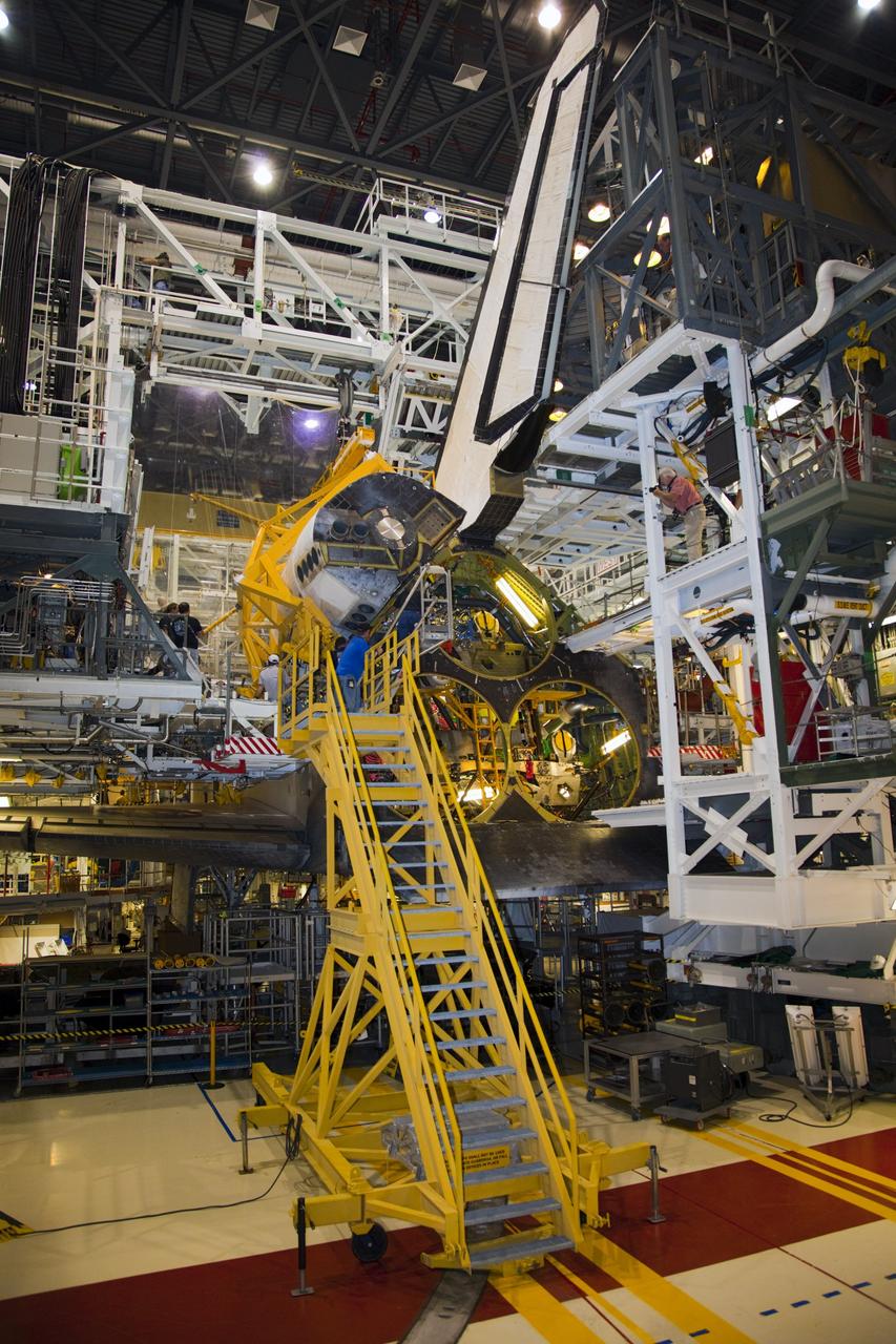 CAPE CANAVERAL, Fla. – In Orbiter Processing Facility-1 at NASA’s Kennedy Space Center in Florida, technicians assist as a crane lowers an orbital maneuvering system (OMS) pod for installation on space shuttle Discovery.      The OMS pod was returned from White Sands Space Harbor in New Mexico where it underwent a complete deservicing and cleaning. The work is part of the Space Shuttle Program’s transition and retirement processing of space shuttle Discovery. The shuttle will go to the Smithsonian’s National Air and Space Museum, Steven F. Udvar-Hazy Center in Chantilly, Va., in April 2012. For more information, visit http://www.nasa.gov/shuttle.  Photo credit: NASA/Frankie Martin
